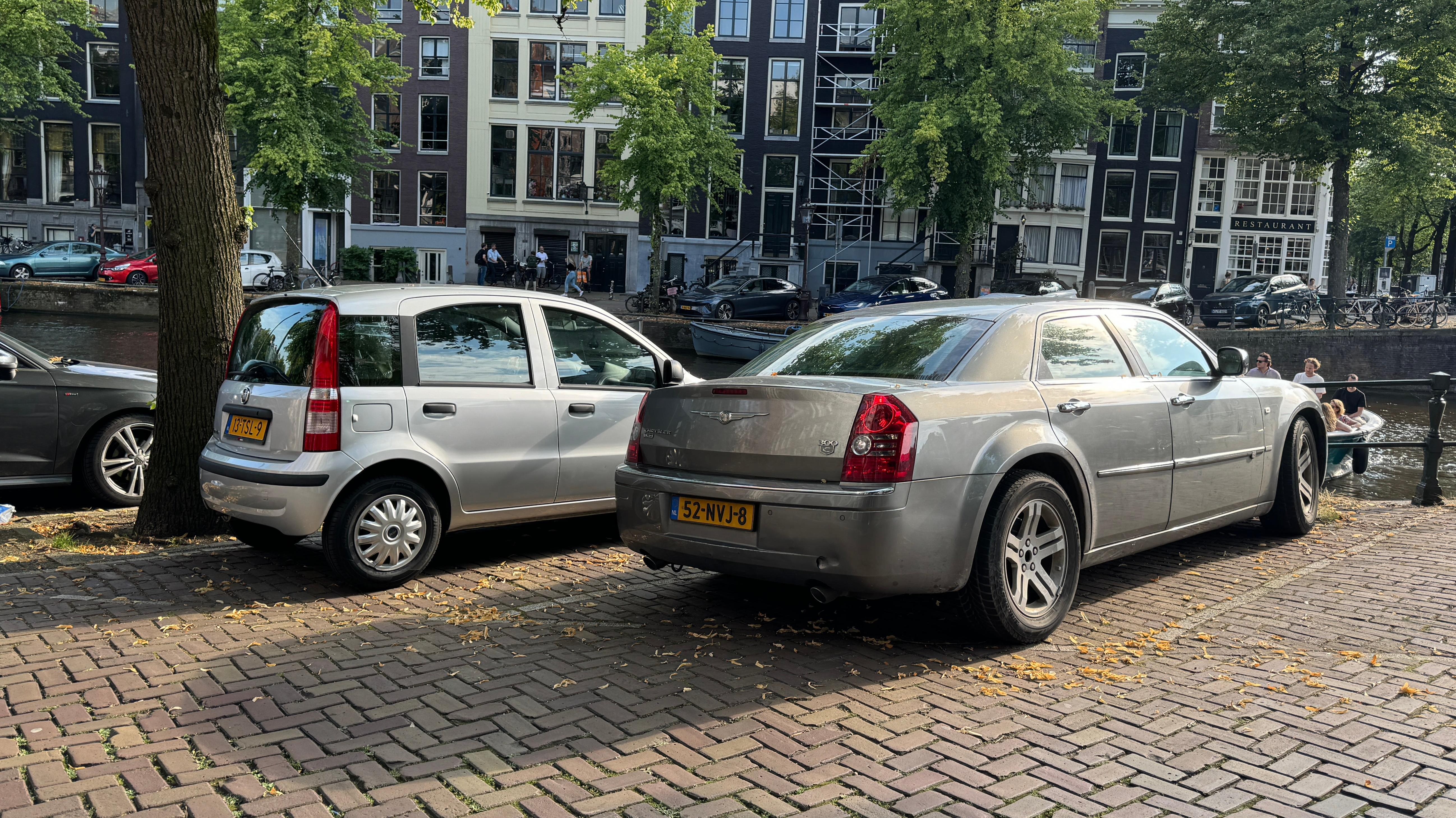 Silver Fiat Panda parked next to a silver Chrysler 300C