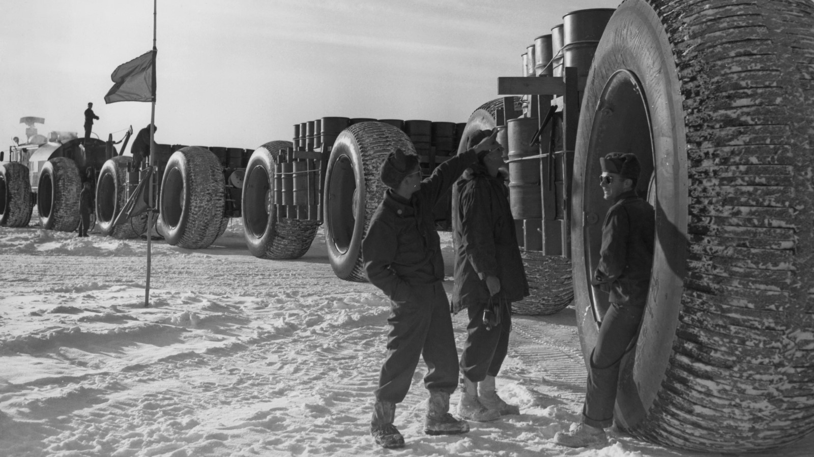 A photo of soldiers leaning against the 10-foot wheels of LCC-1. 