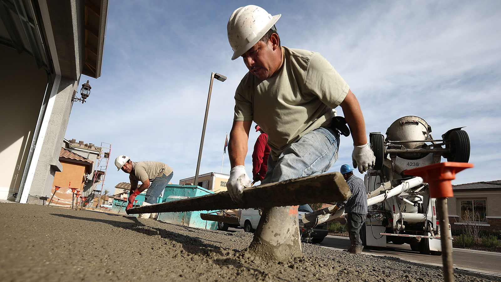 Construction workers build a concrete driveway. 