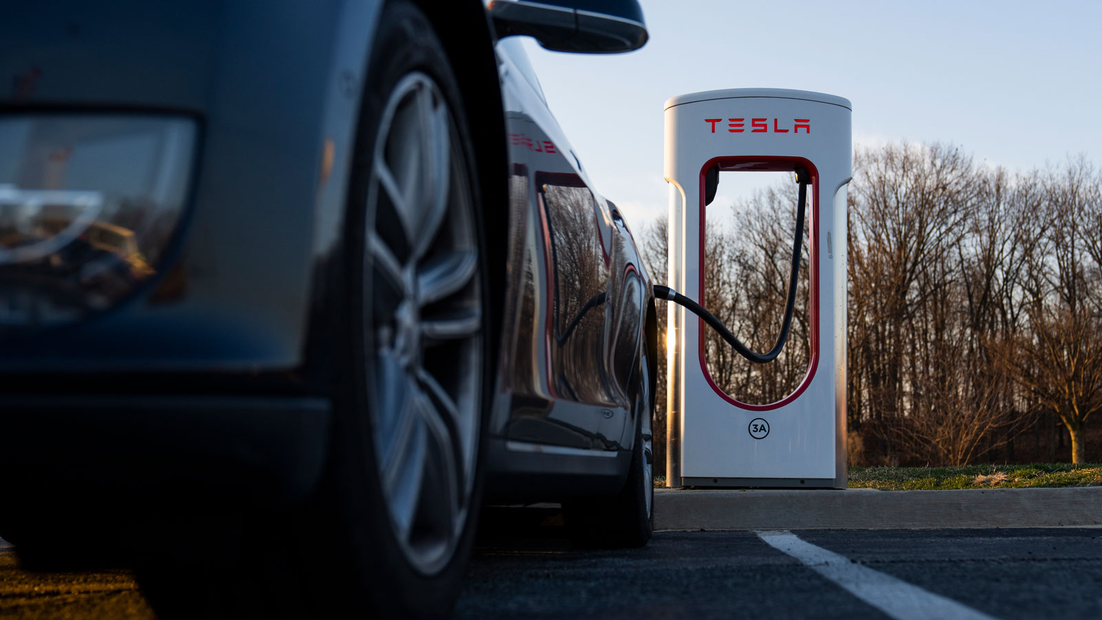 A photo of a Tesla plugged into a Surpercharger. 