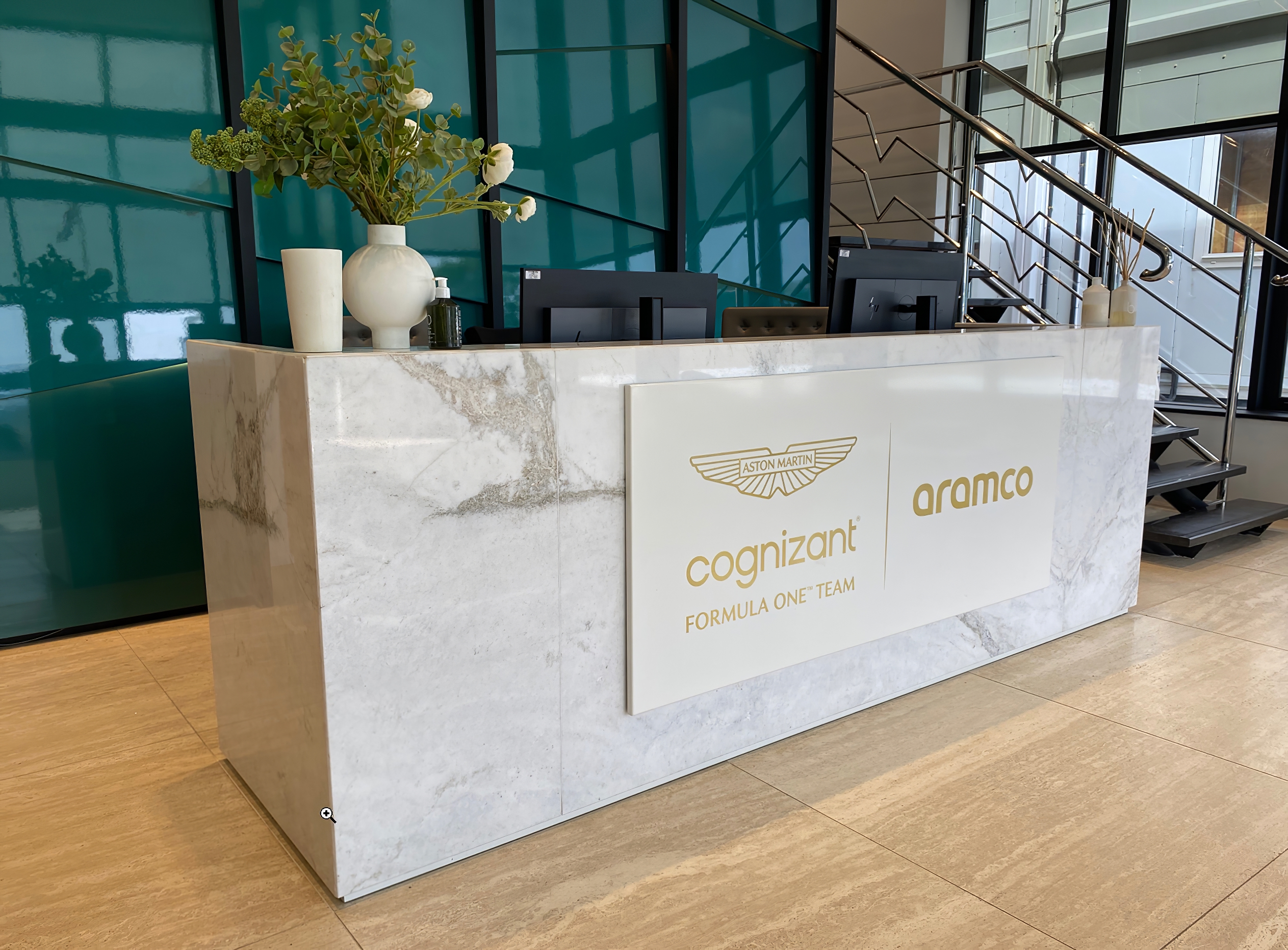 A marble reception desk adorned with an Aston Martin F1 sign