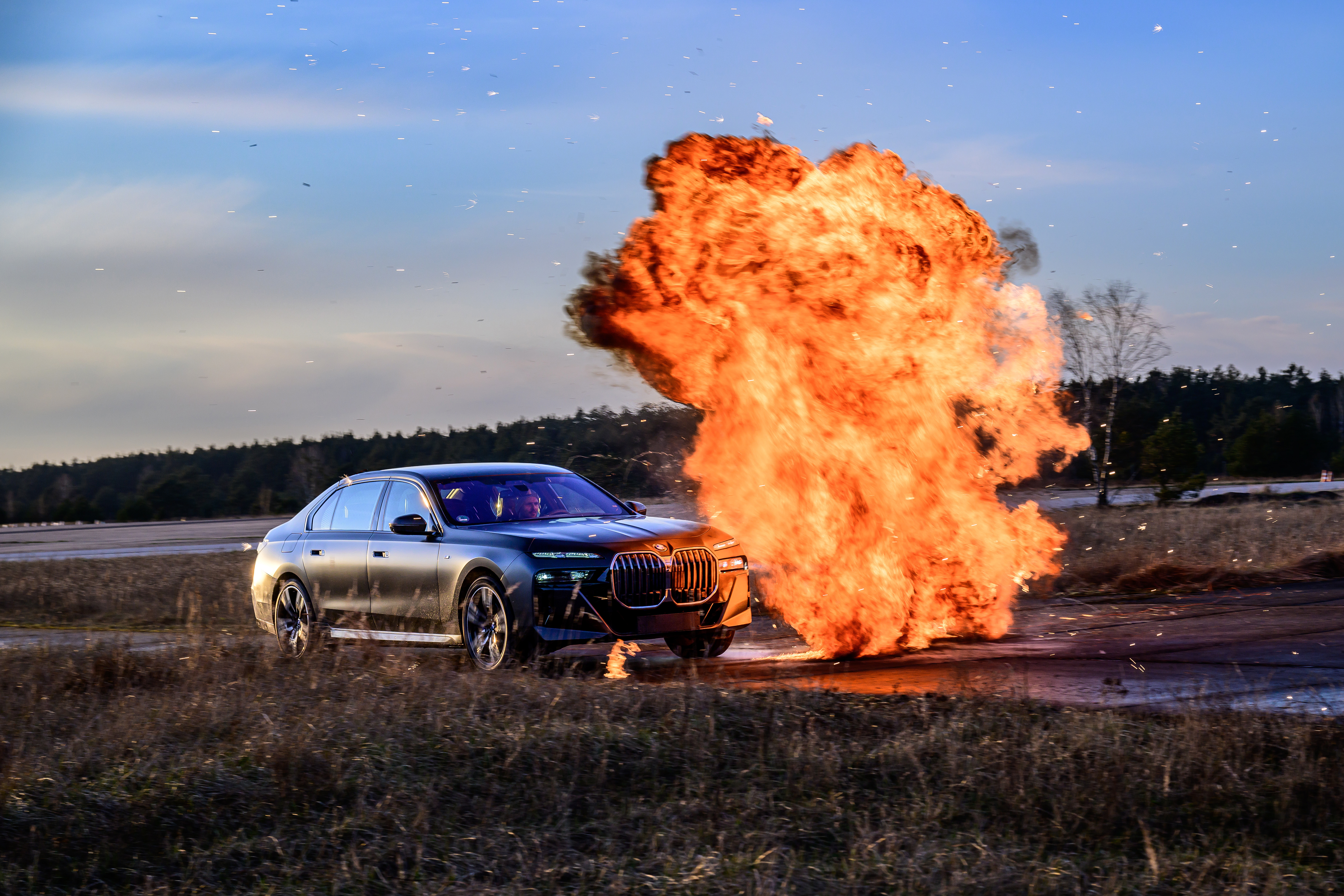 Front 3/4 view of an armored BMW 7 Series avoiding an explosion