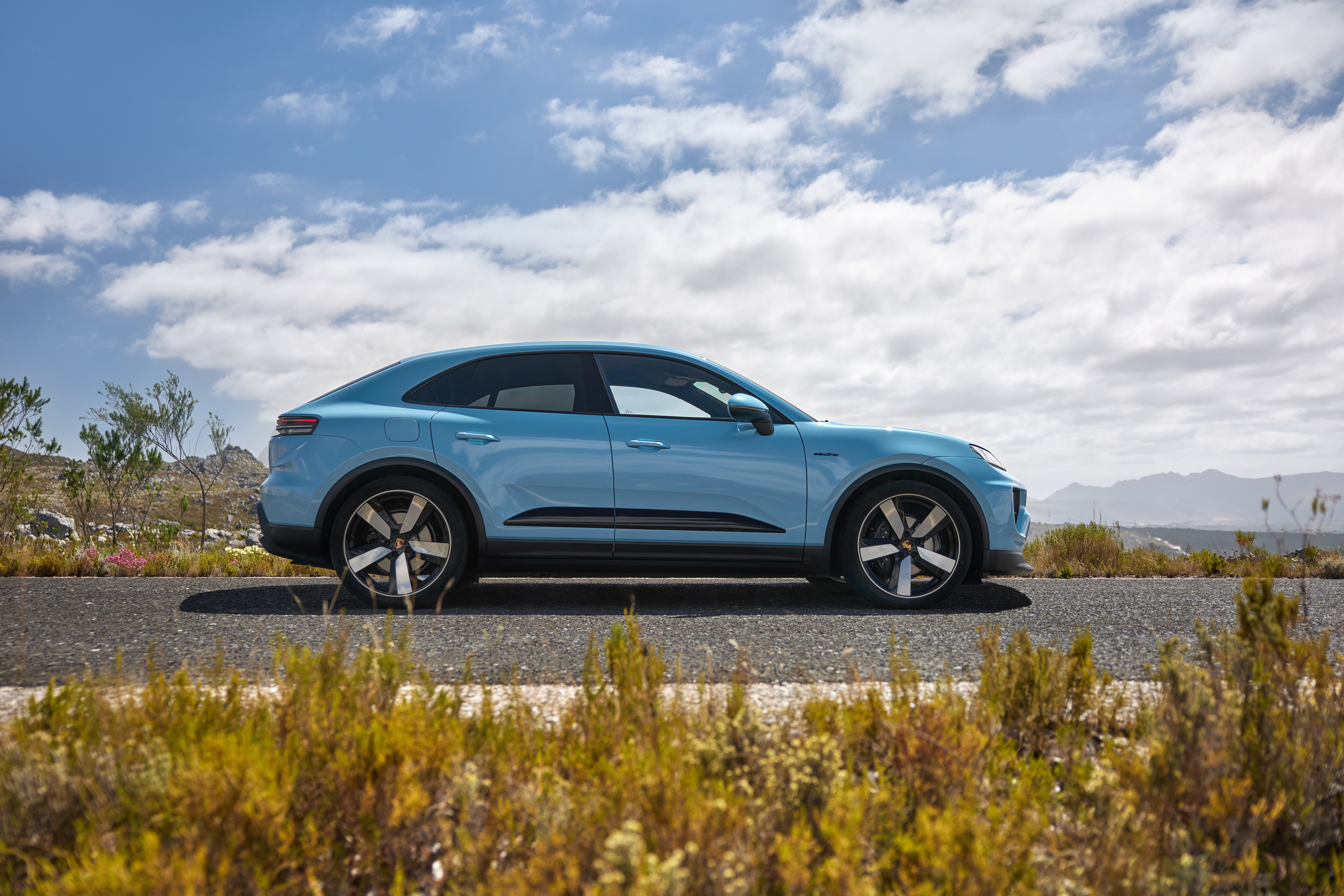 Side view of a blue Porsche Macan Electric