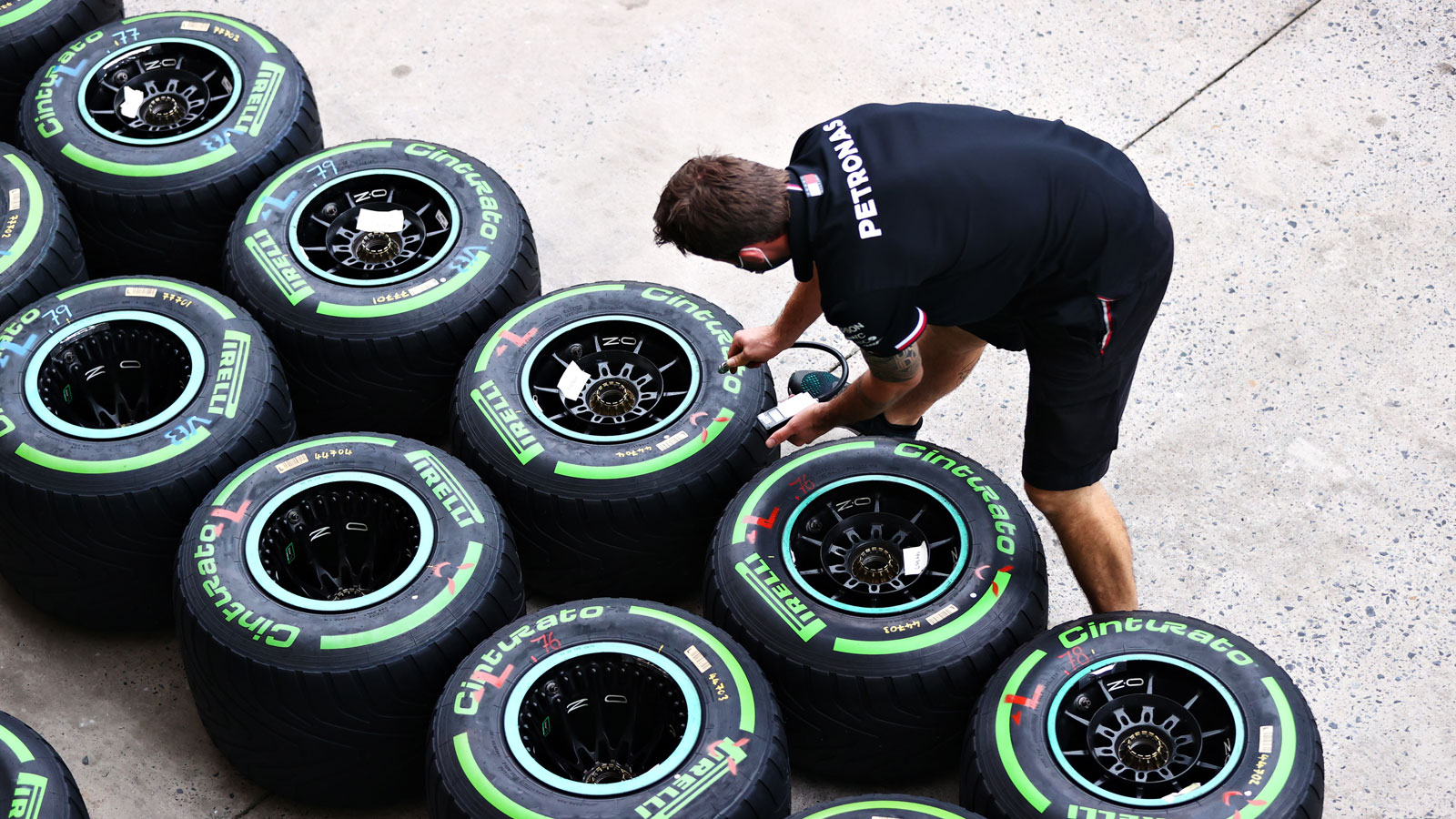 A mechanic inspects sets of F1 wheels. 