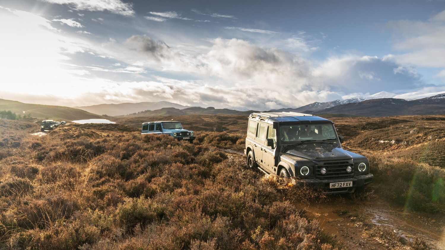 A photo of Ineos Grenadier cars driving off-road in Scotland. 