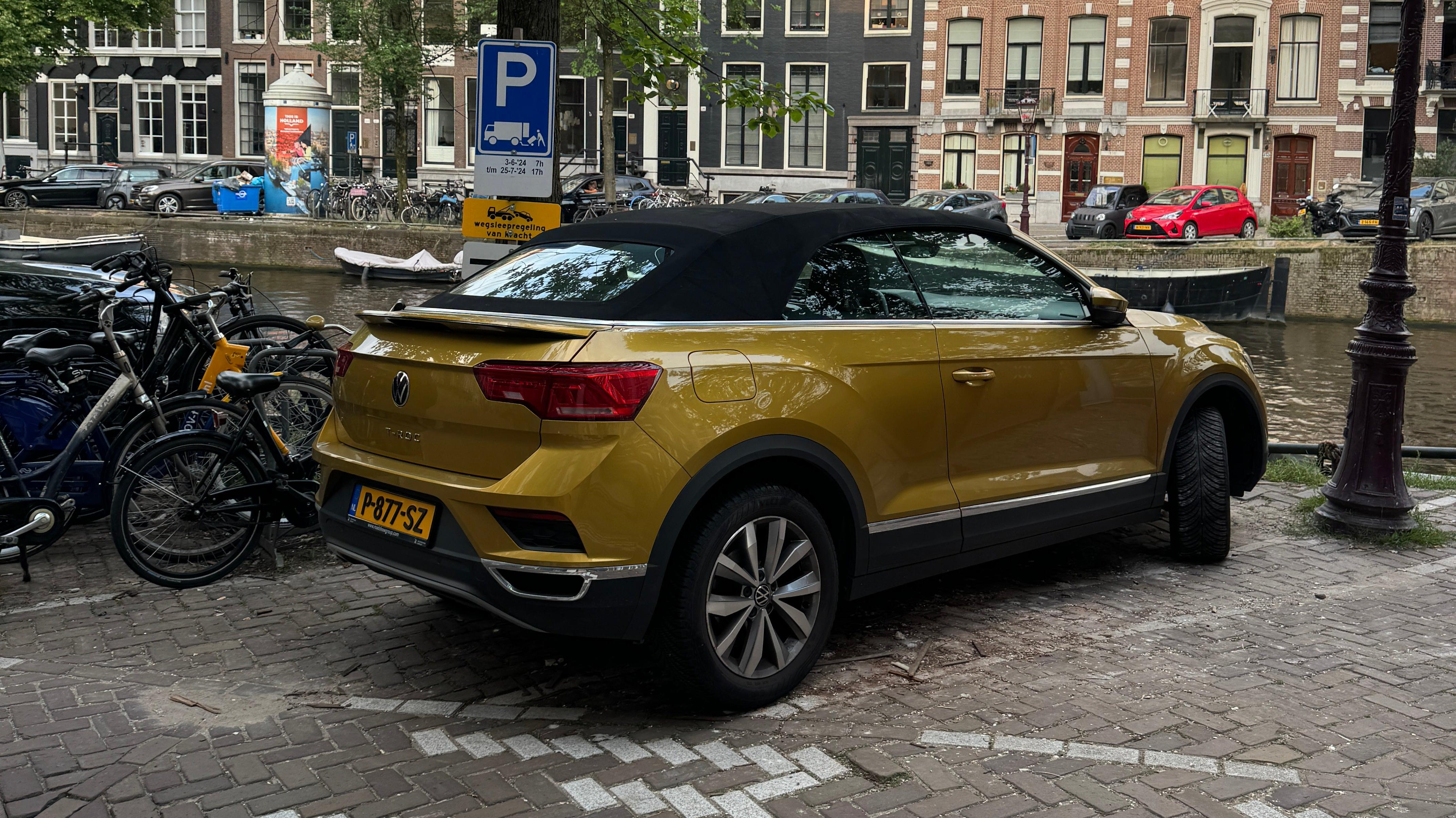 Rear 3/4 view of a yellow Volkswagen T-Roc convertible