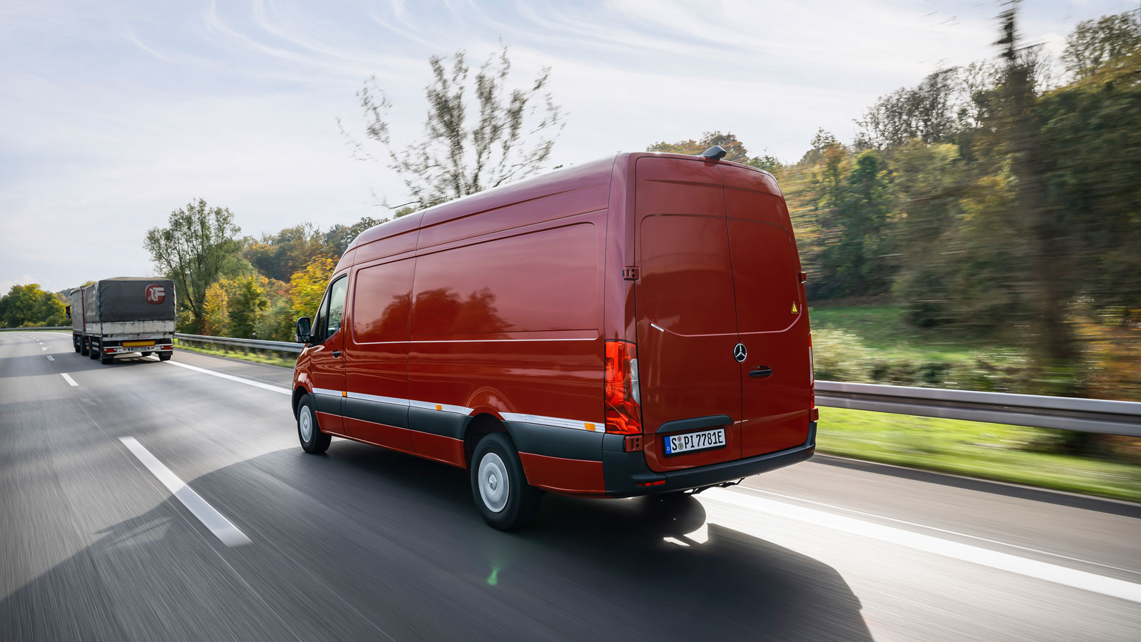 A photo of the rear quarter on a red Mercedes Sprinter van. 