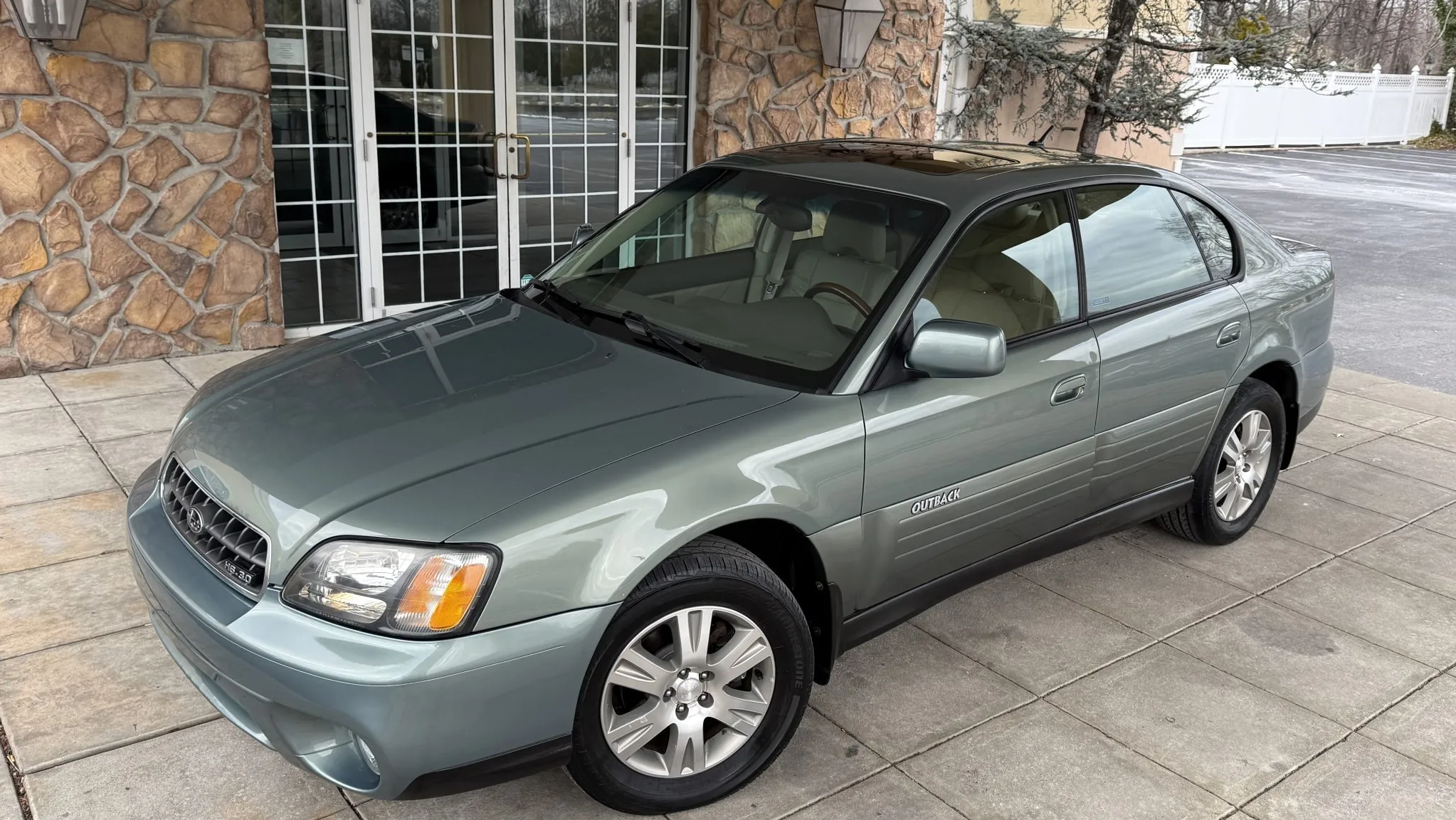 a light green second-gen Subaru Outback Sedan