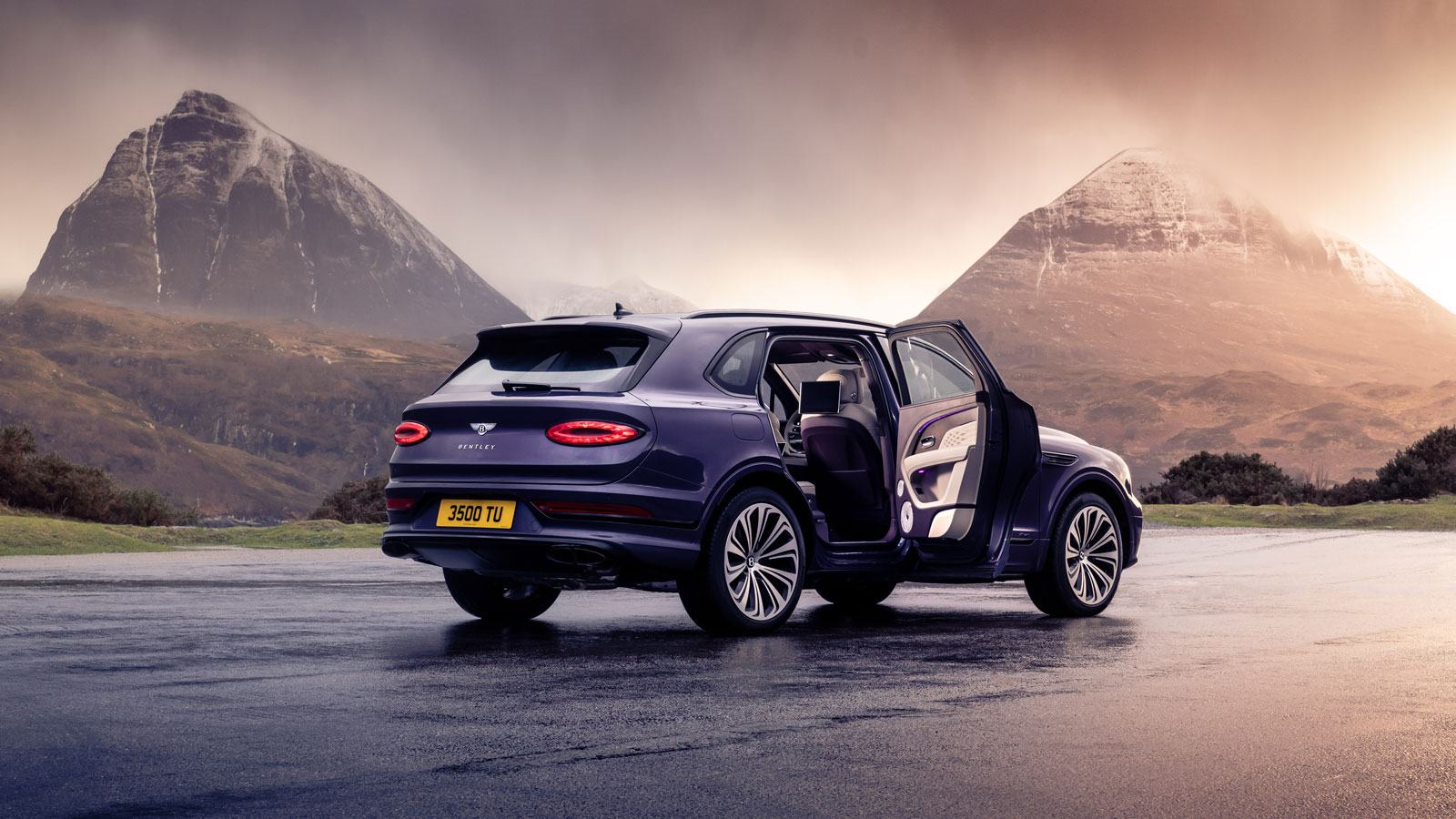 A photo of a purple Bentley Bentayga SUV parked with a door open. 