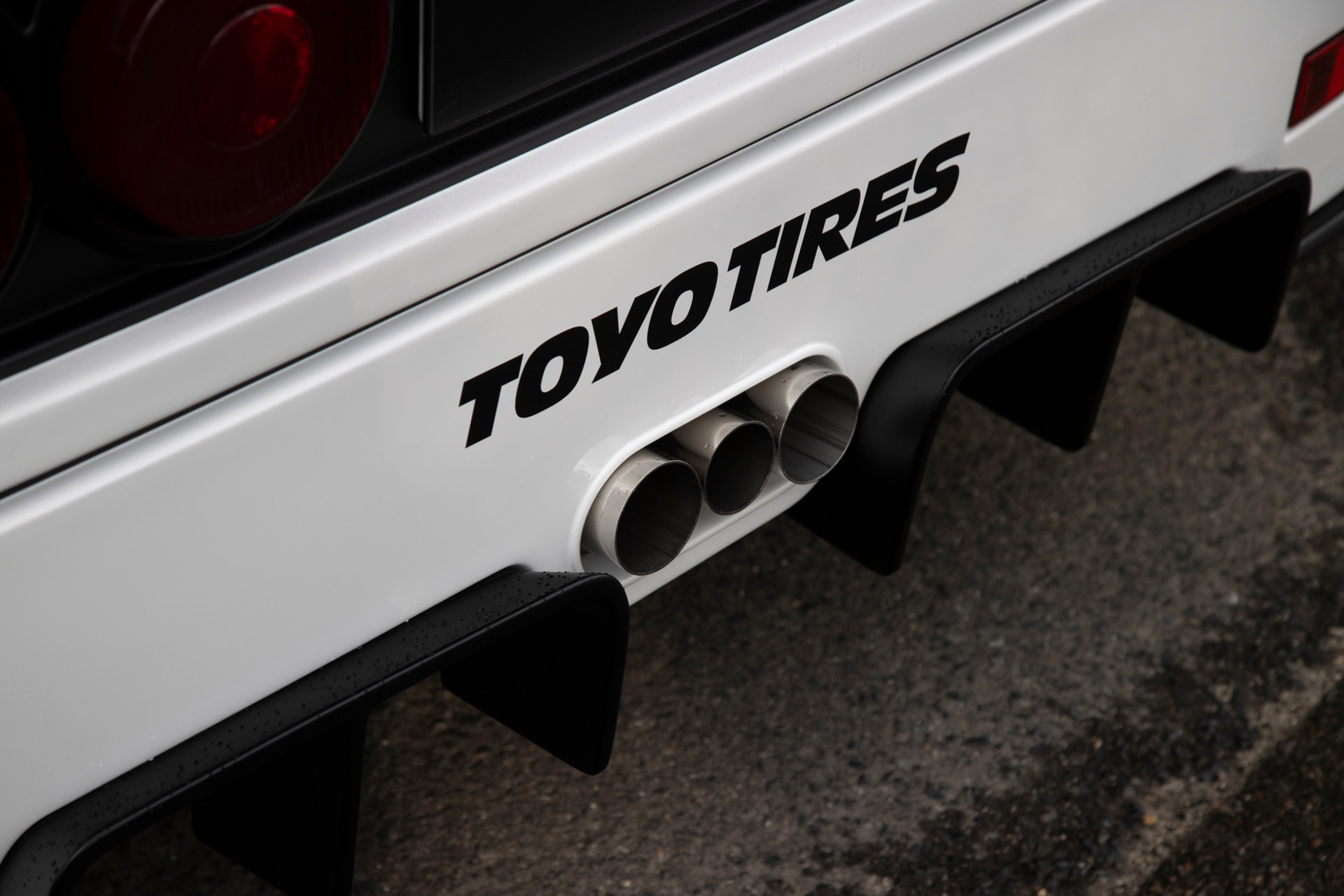 Exhaust tips of a white Autozam AZ-1 with a Ferrari F40 bodykit