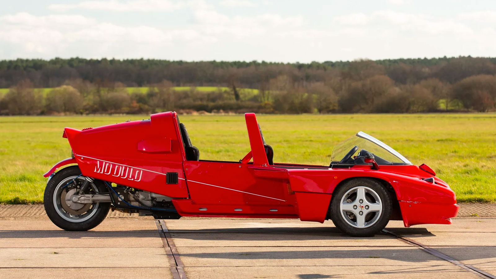 A photo of the side of a Modulo three-wheeled car. 