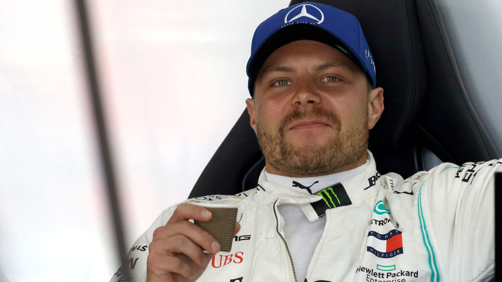 A photo of Valtteri Bottas drinking coffee in the F1 garage. 