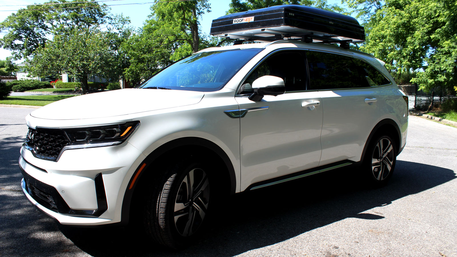 A side profile image of a white Kia Sorento plug-in Hybrid SUV. 