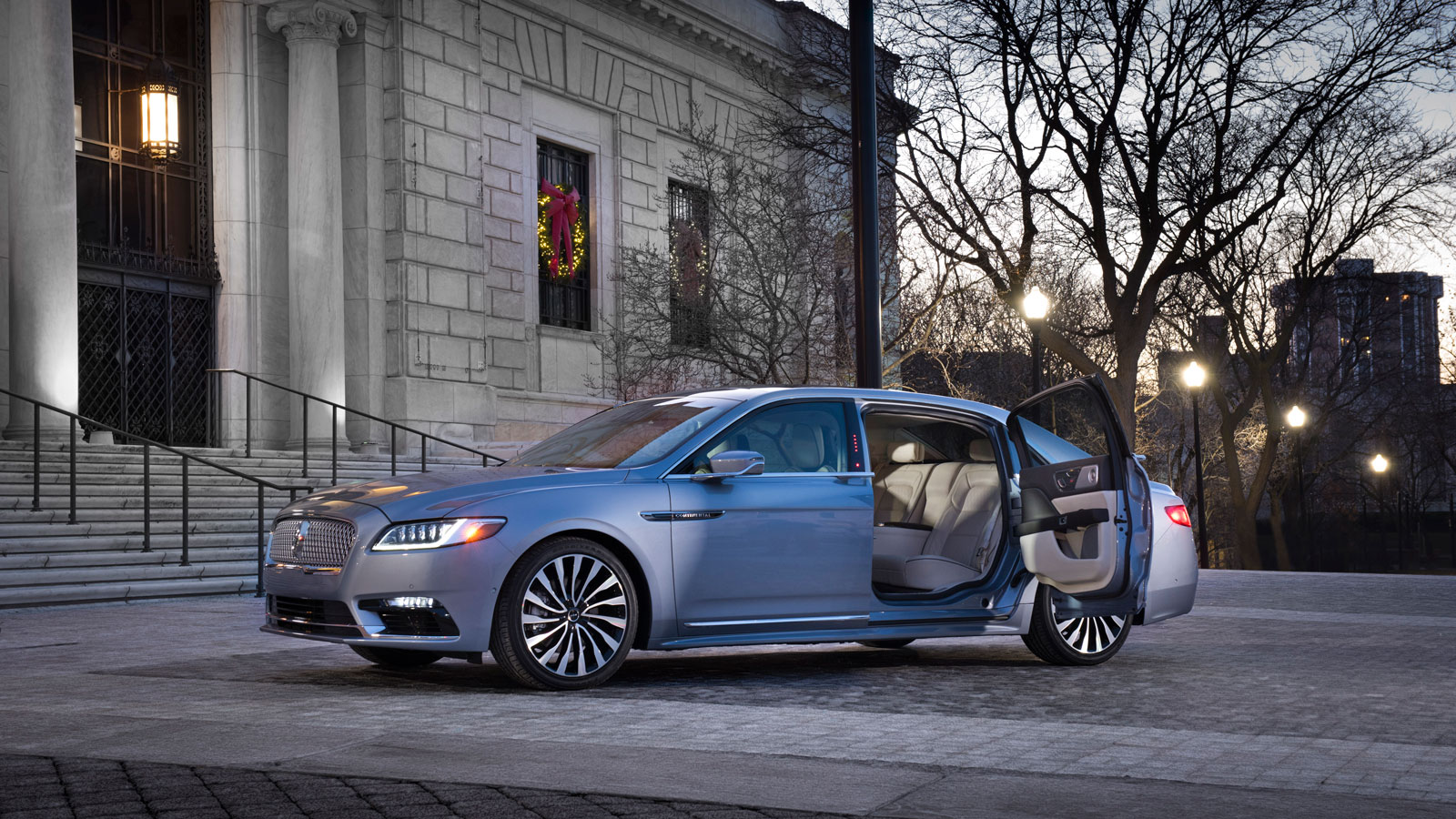 A photo of a blue Lincoln Continental with its suicide doors open. 