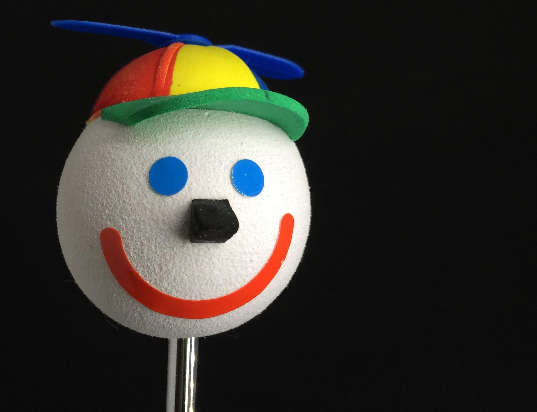 A 'Jack in the Box' smiling happy face car antenna ball topper with a spinning baseball cap