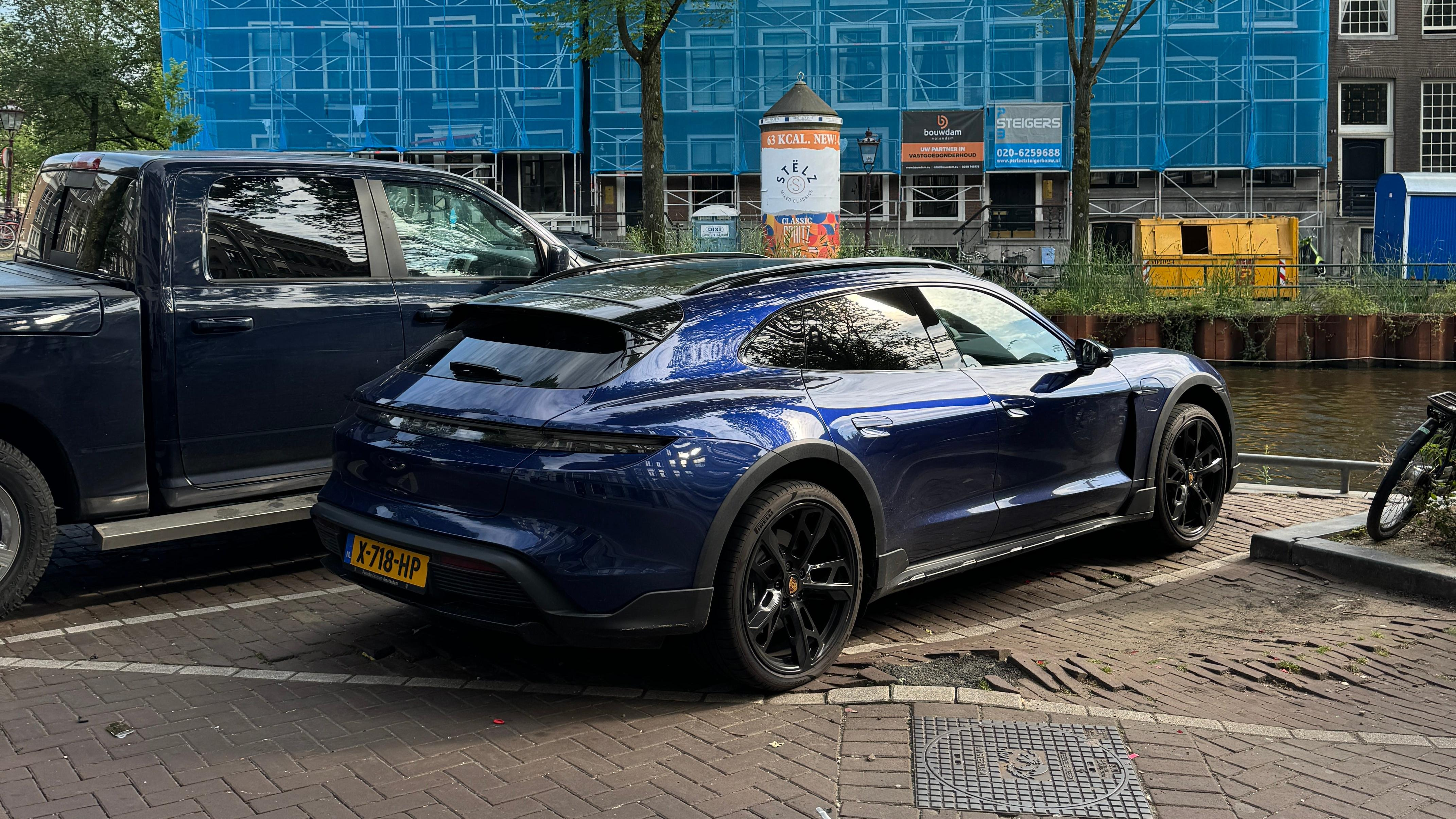 Rear 3/4 view of a blue Porsche Taycan Cross Turismo