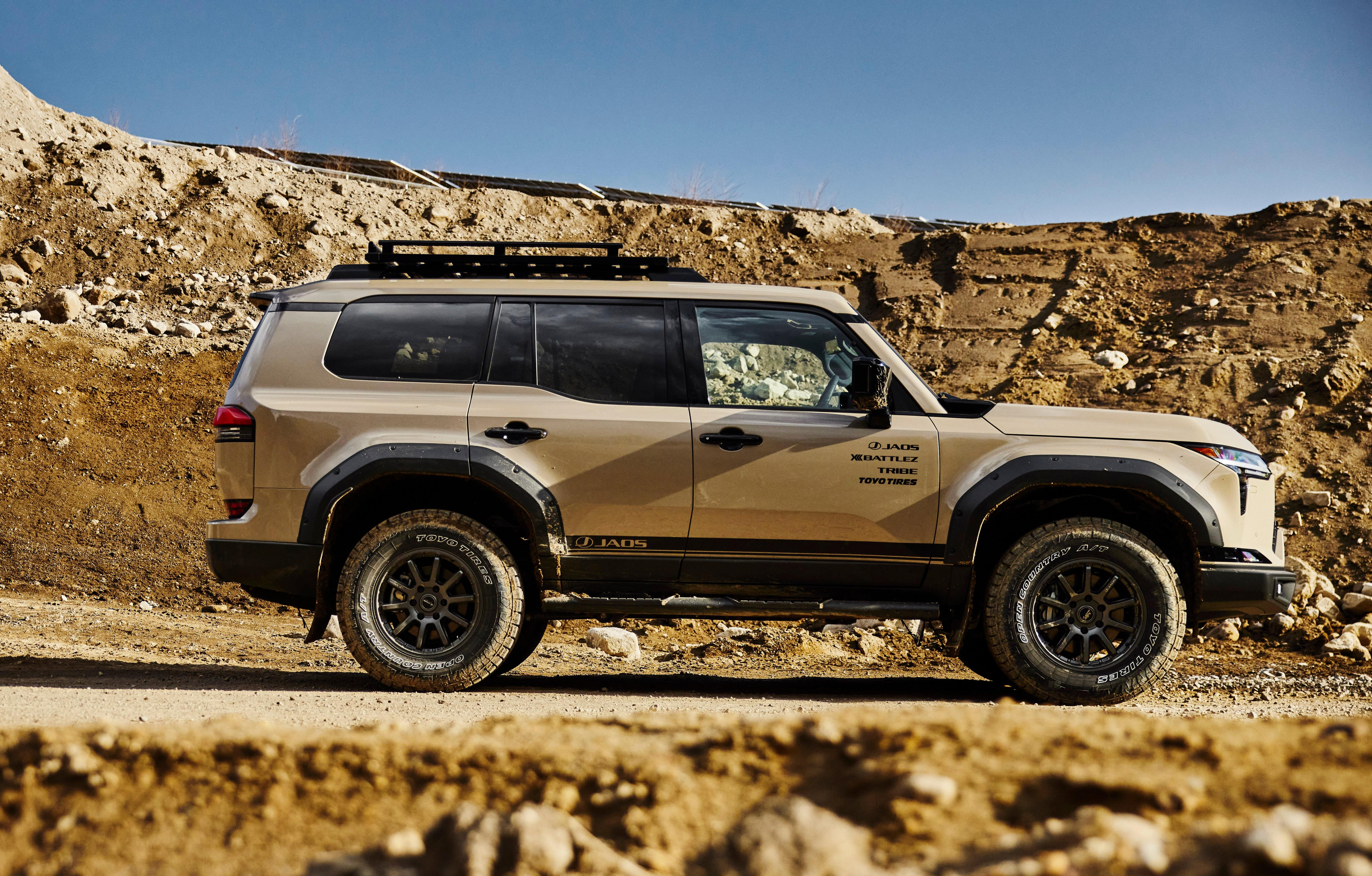 Side view of a modified beige Lexus GX in a dirt gorge