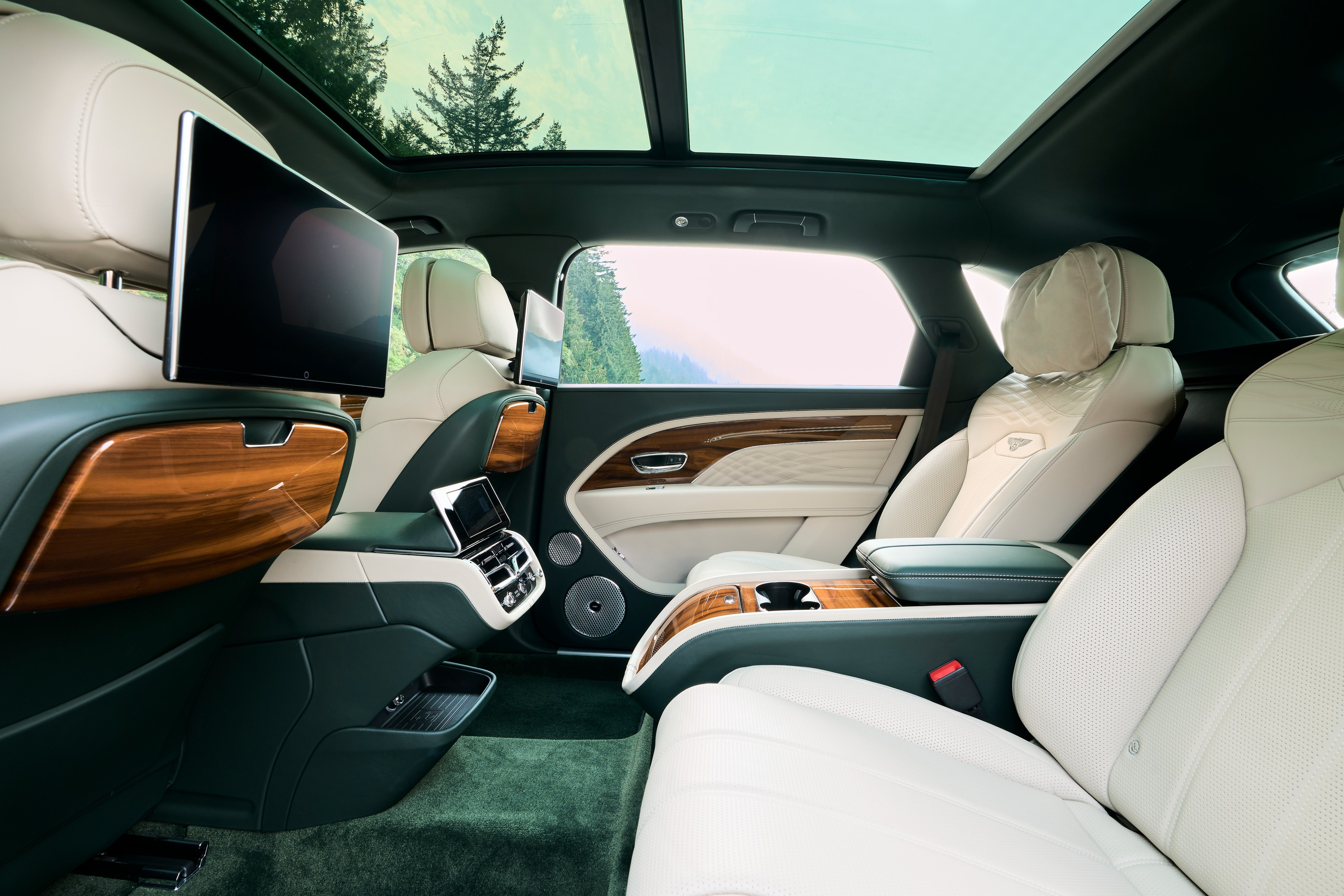 The rear seating area of a Bentley Bentayga EWB in green and tan leather.