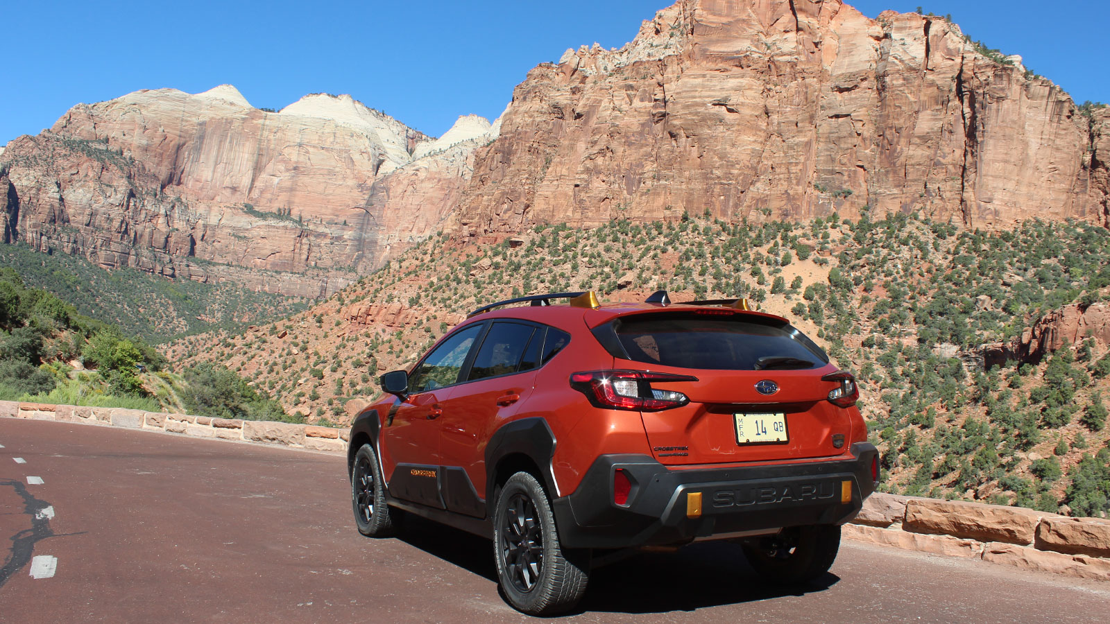 A photo of the rear quarter of a Subaru Crosstrek Wilderness in a national park. 