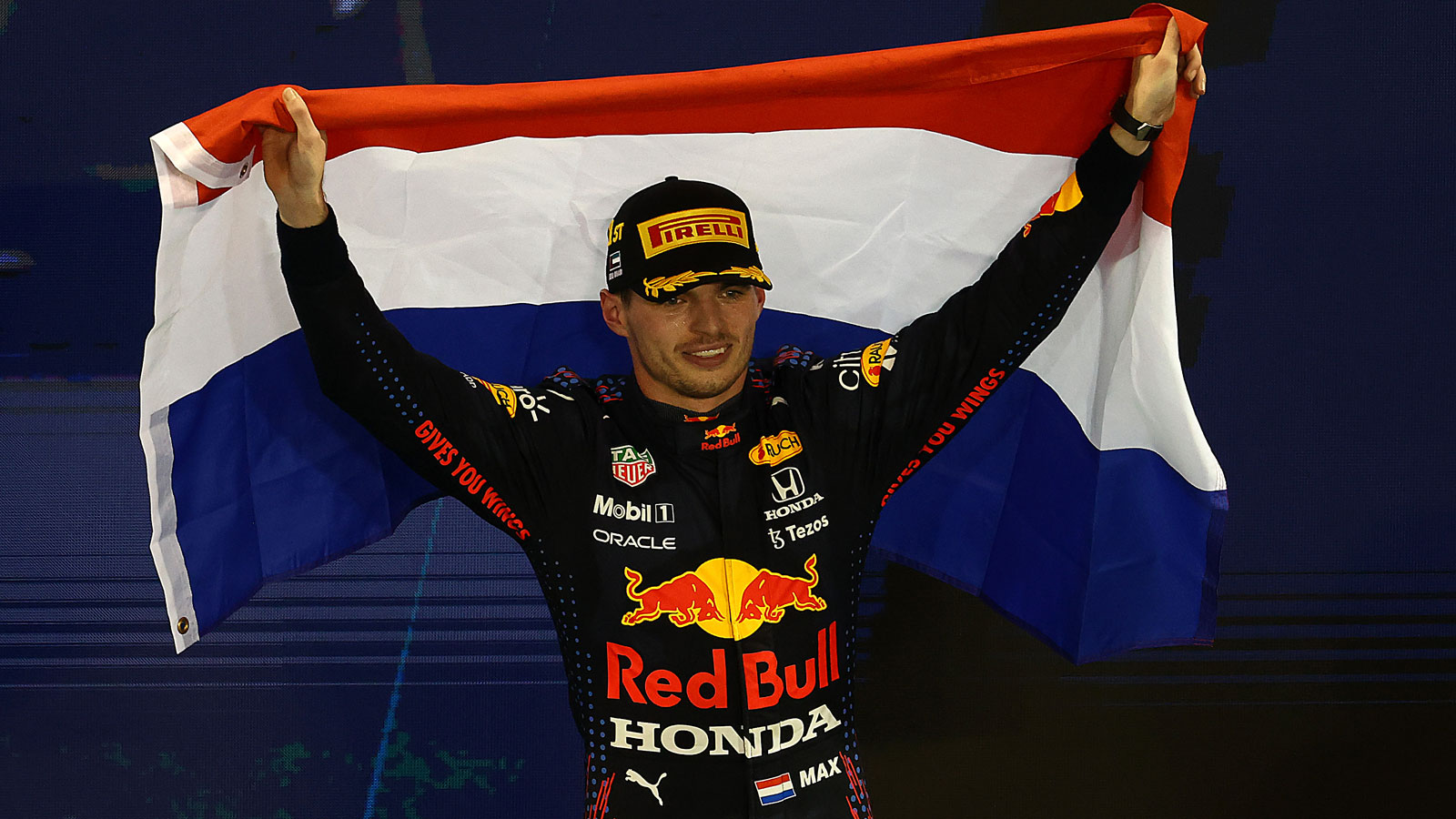 Max Verstappen holds a Dutch flag over his head