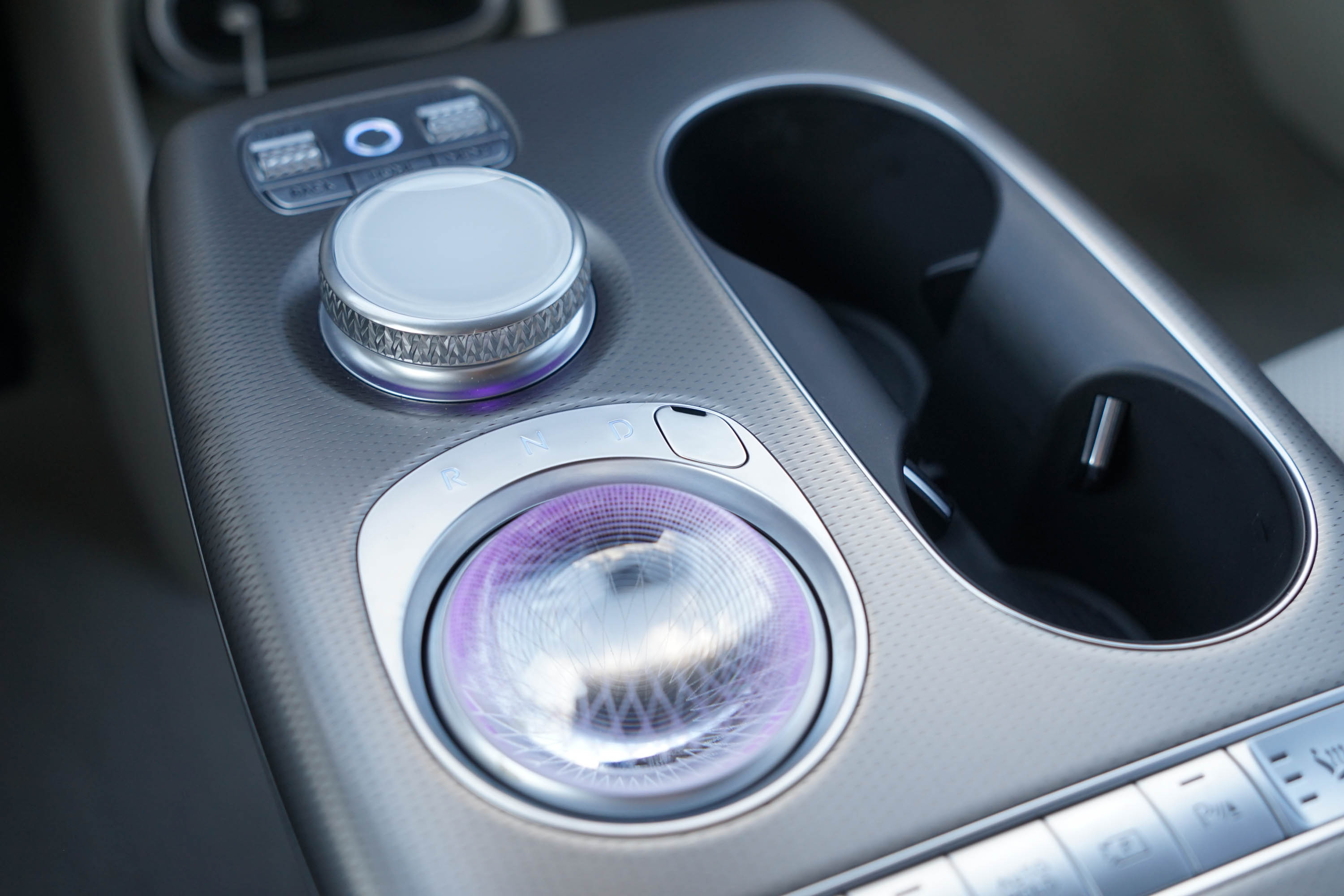 The shifter of the 2023 Genesis GV60 in its resting position, displaying an LED lit crystal ball.