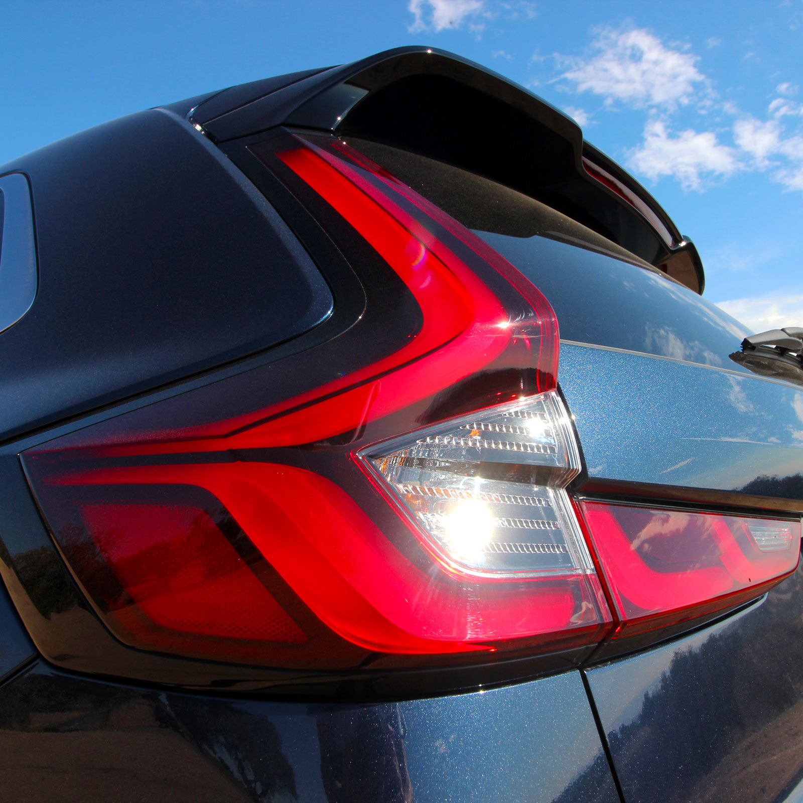 A photo of the left rear light on a blue Honda CR-V SUV. 