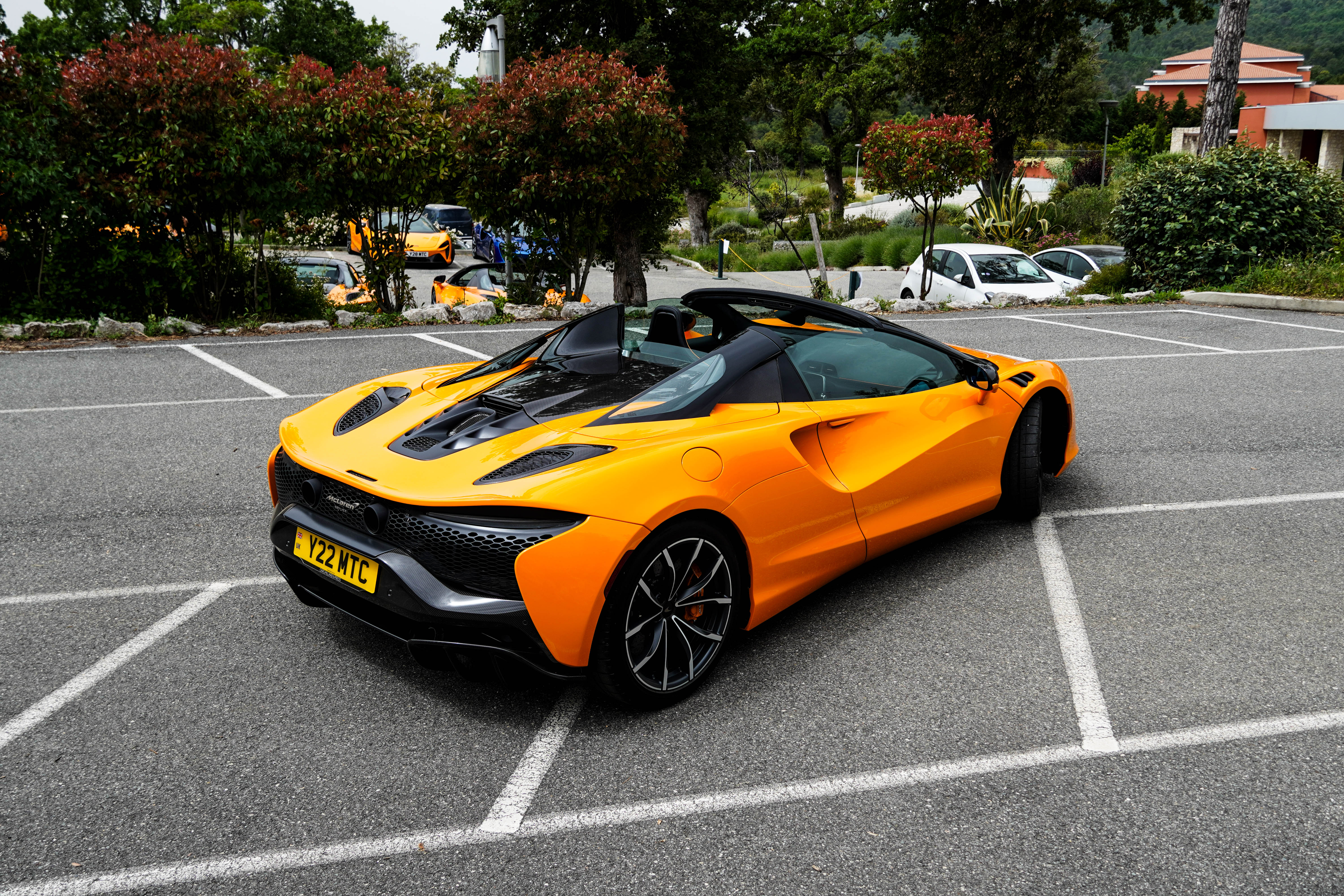 Rear 3/4 view of an orange McLaren Artura Spider