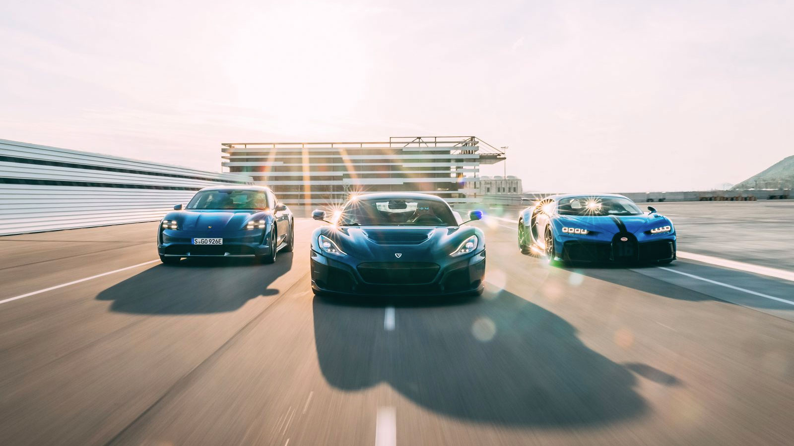 A Porsche, Rimac and Bugatti driving down a road 