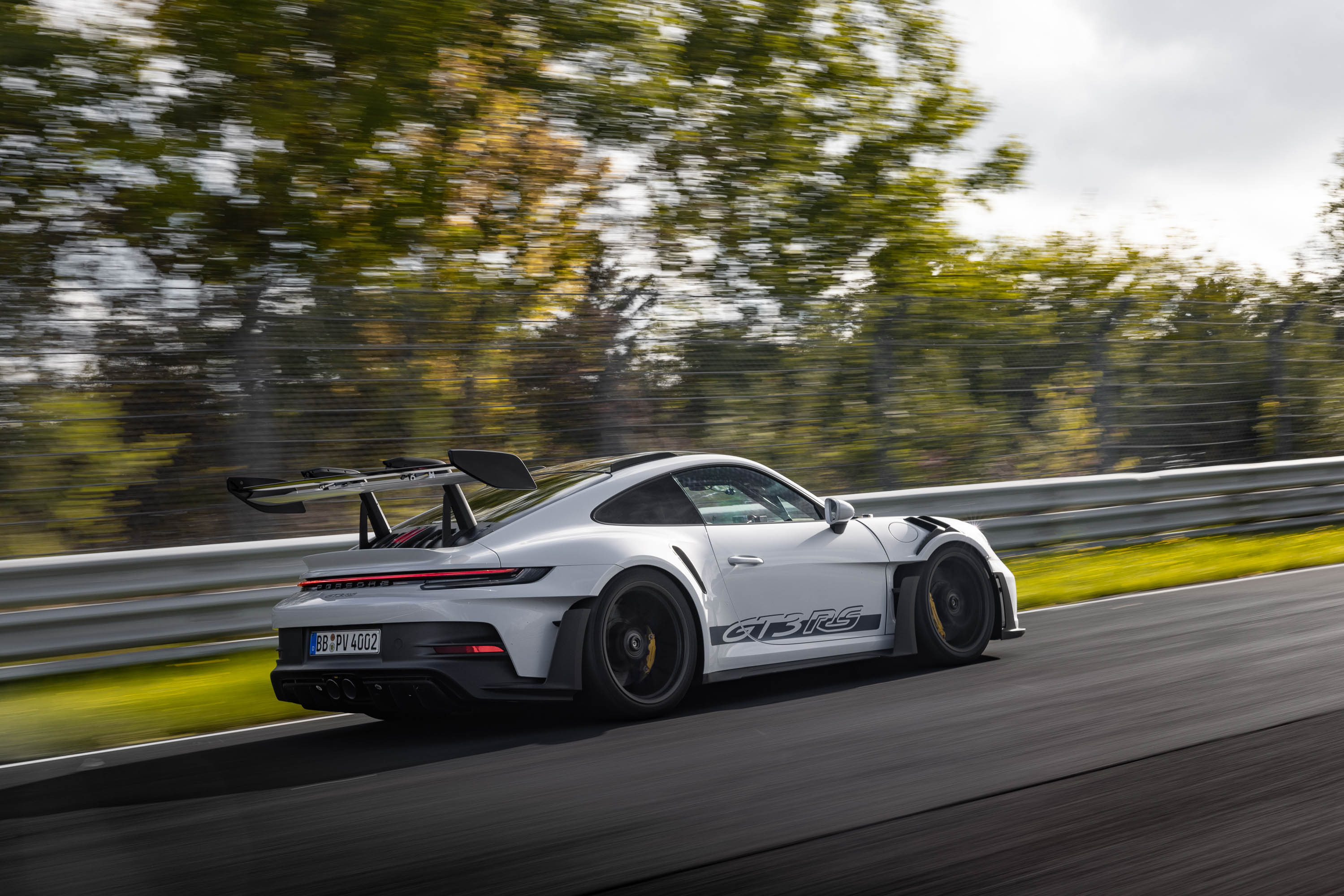 A silver GT3 RS driving on track.