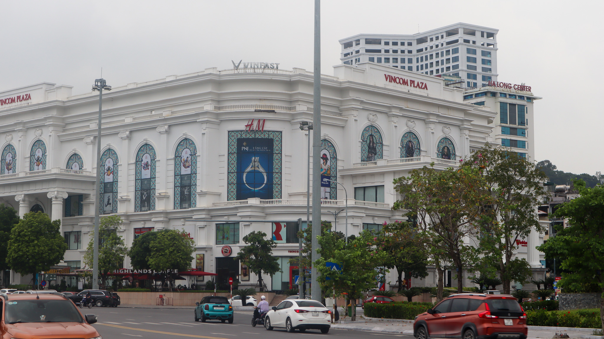 A Vingroup Vincom shopping plaza on the corner of two busy streets.