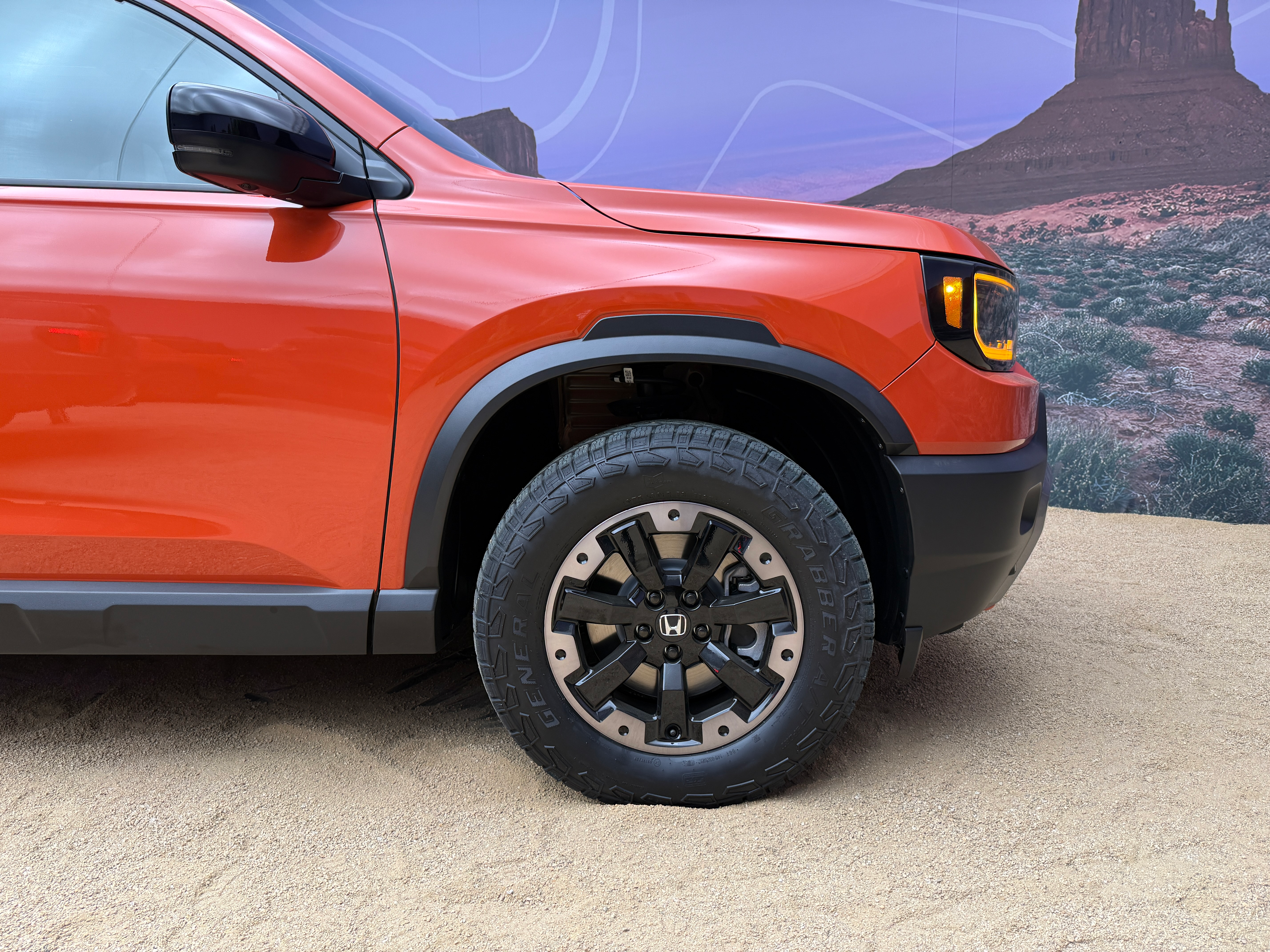 Front wheel of an orange 2026 Honda Passport TrailSport