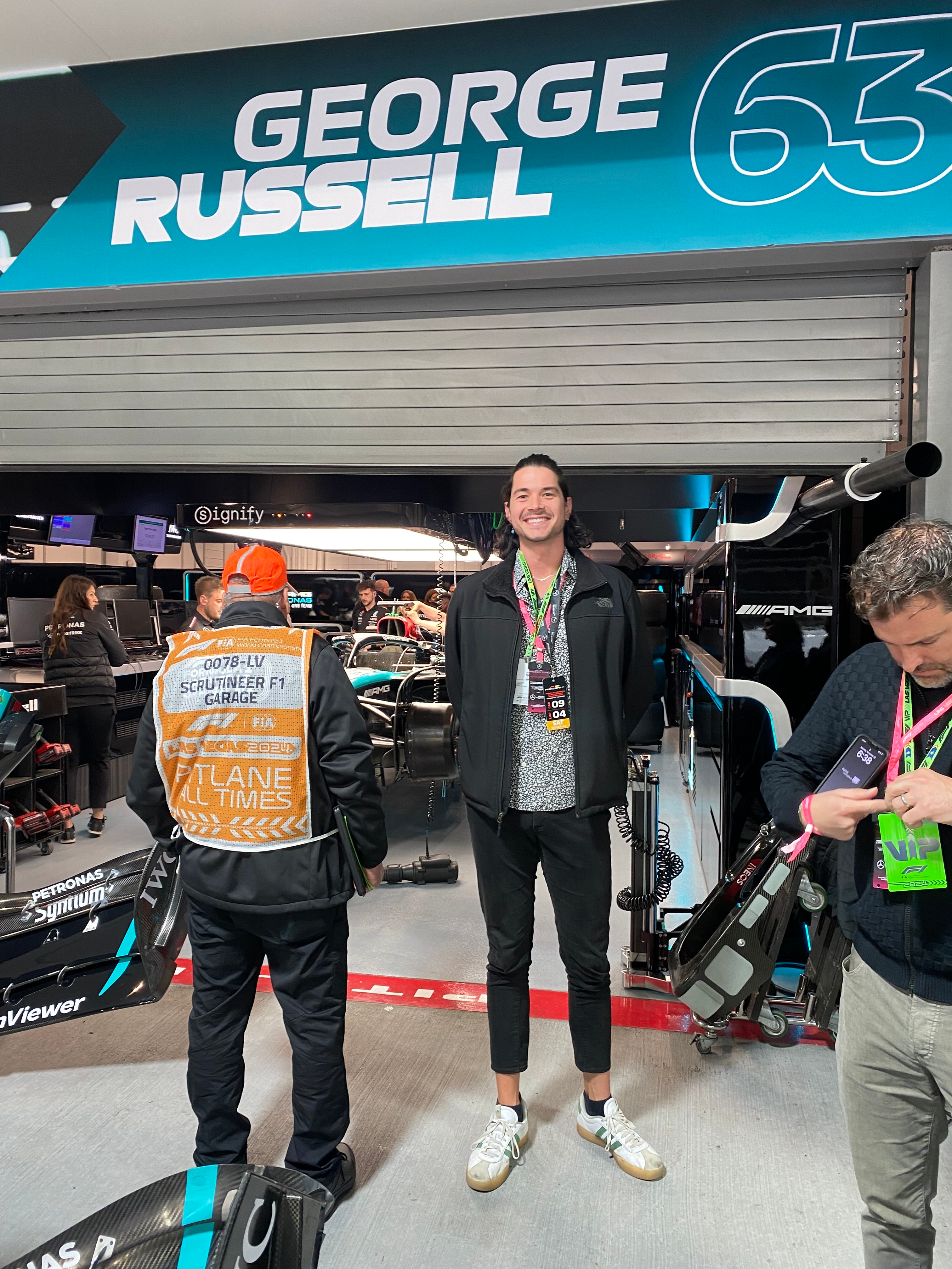 A photo of me standing in front of George Russell's garage with his car inside