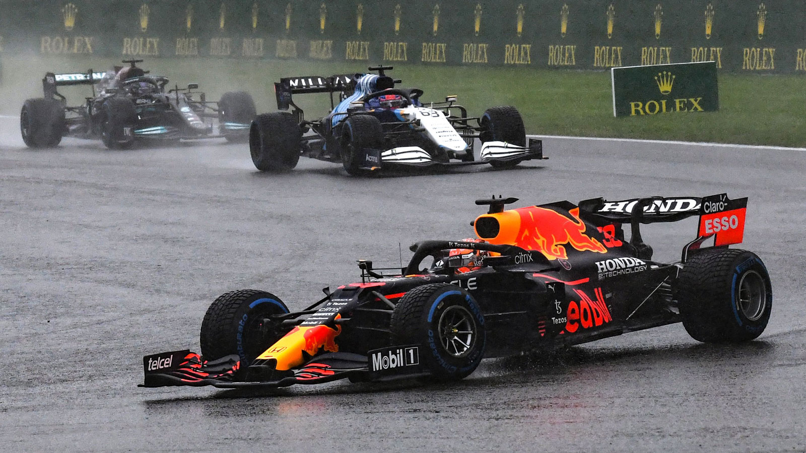 Three Formula 1 cars try to drive round a flooded race track 