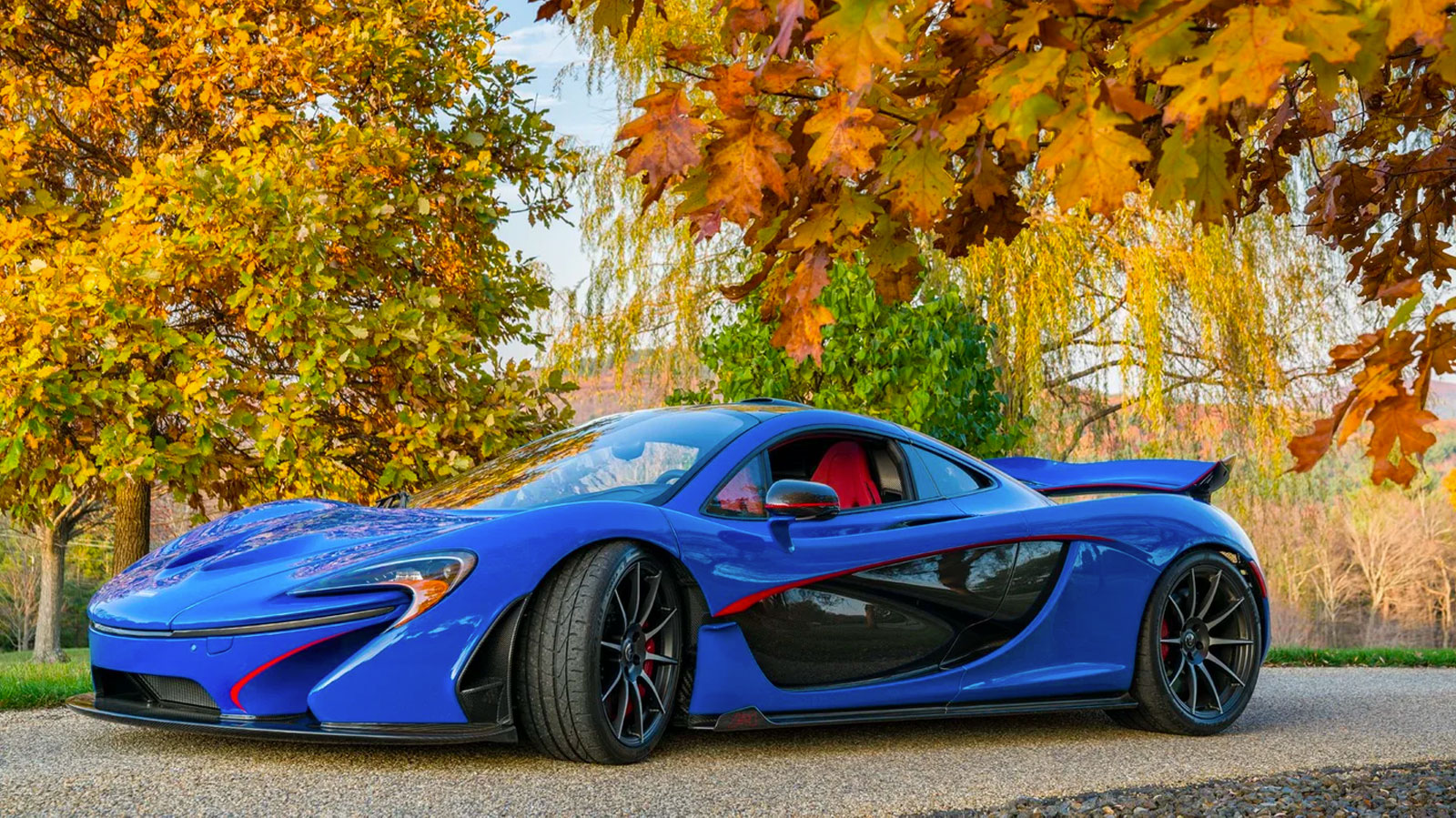 An electric blue McLaren P1 with red and black detailing 