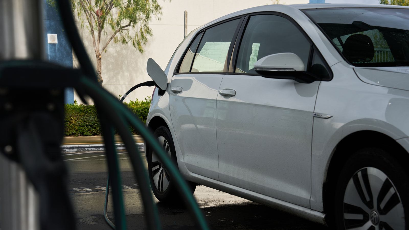 A photo of an electric car charging at a port. 