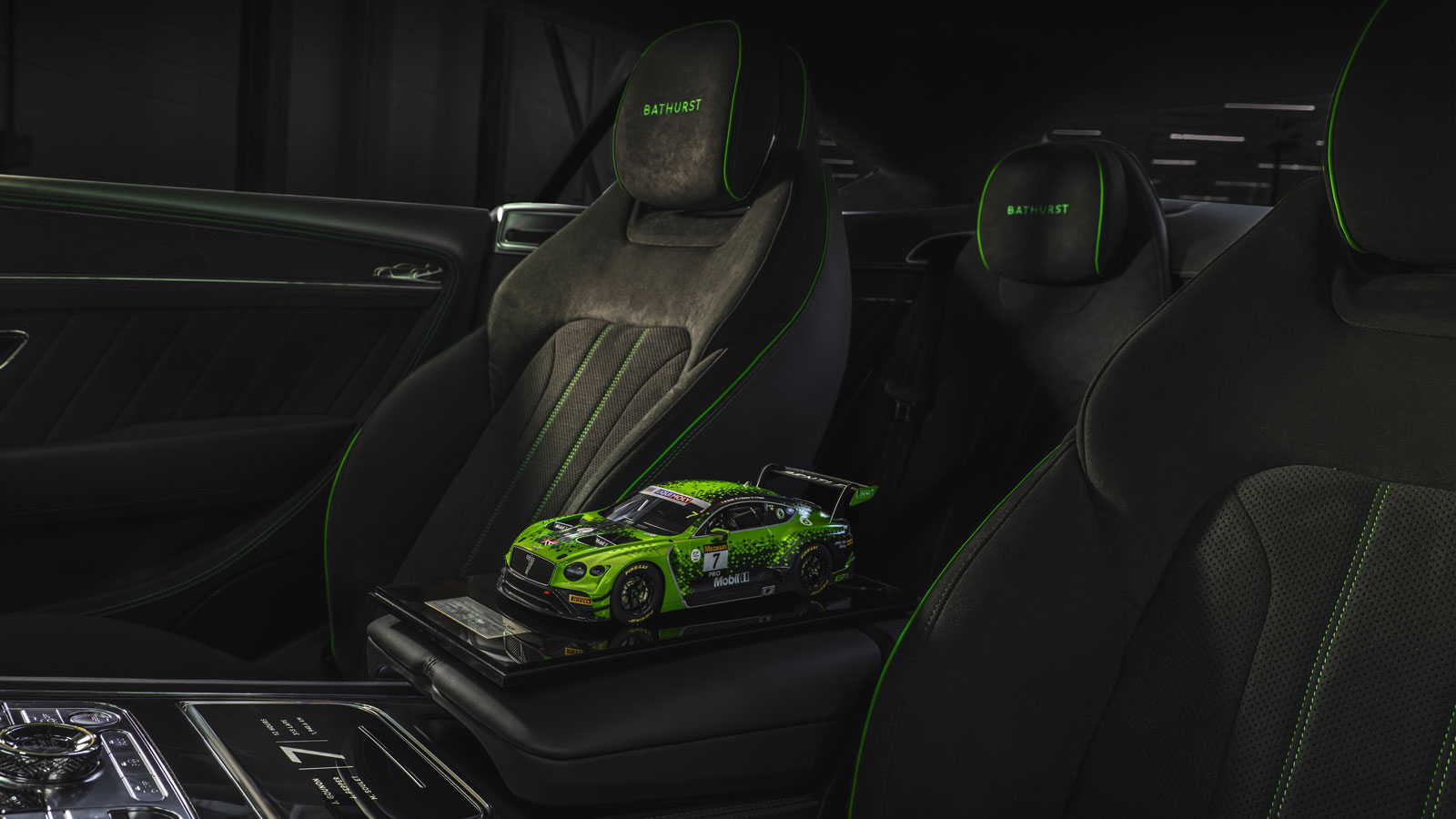 a photo of the black and green interior of the limited edition Bentley with a model car on the seat. 