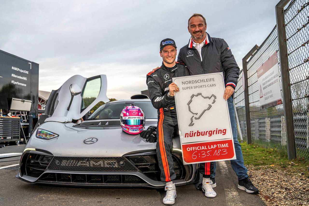 Driver Maro Engel holding up his official lap time in front of a Mercedes-AMG One