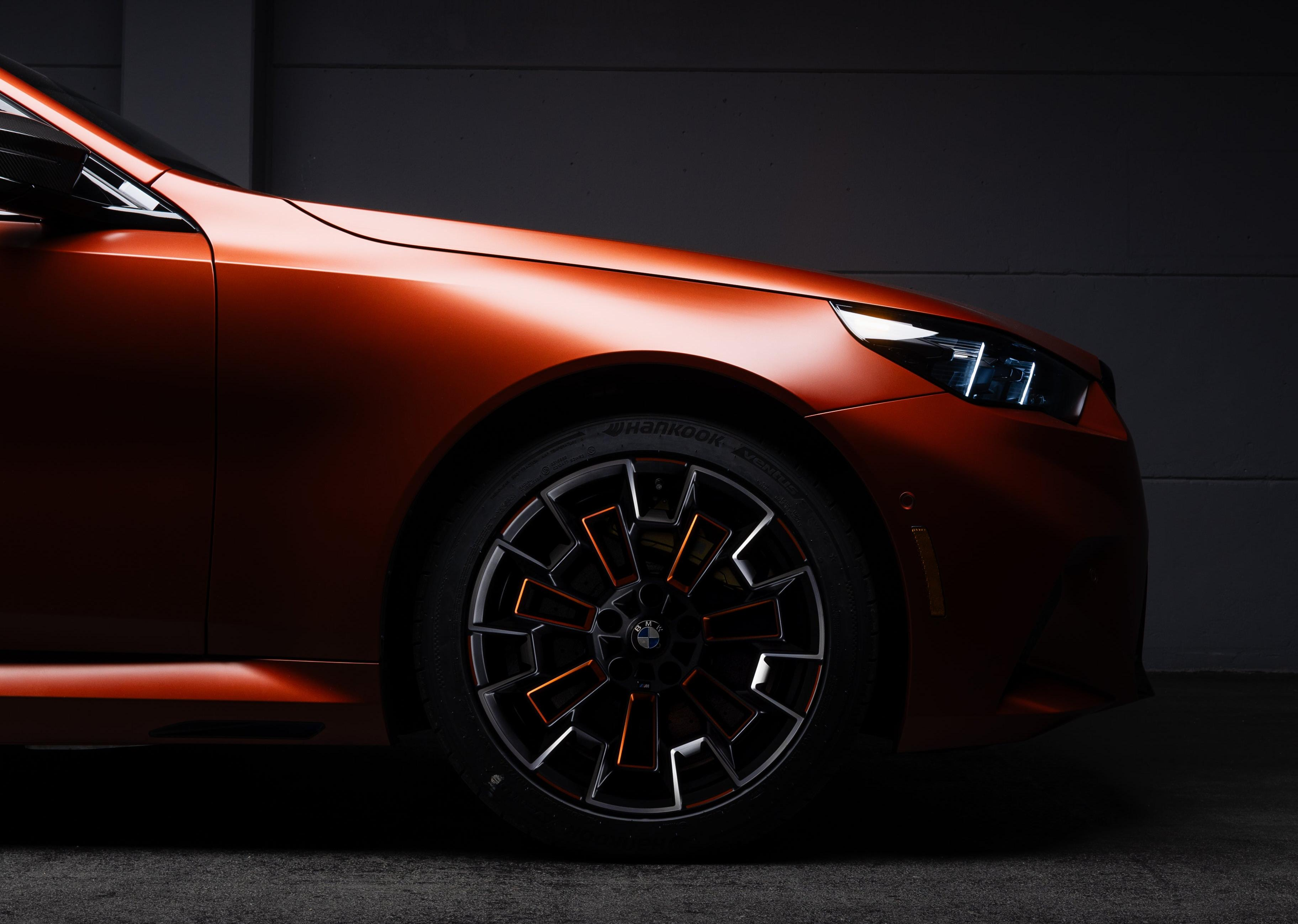 Front wheel of a matte orange 2025 BMW M5