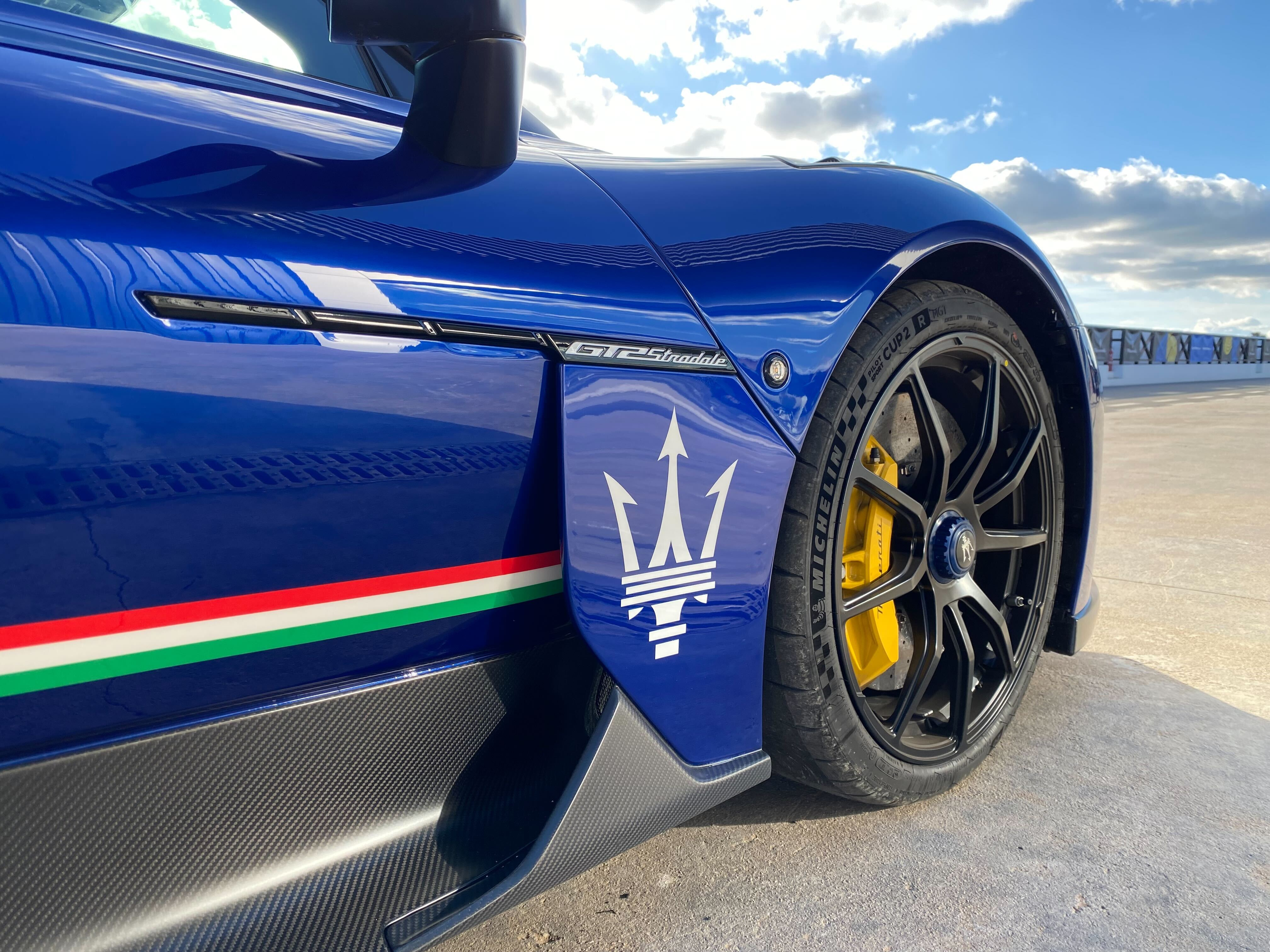 a close up of the maserati trident on the font fender of a GT2 Stradale