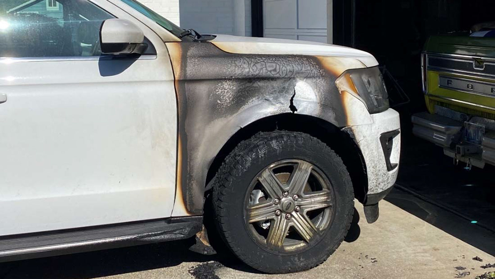 A photo of a burned fender and wheel on a Ford Expedition SUV. 