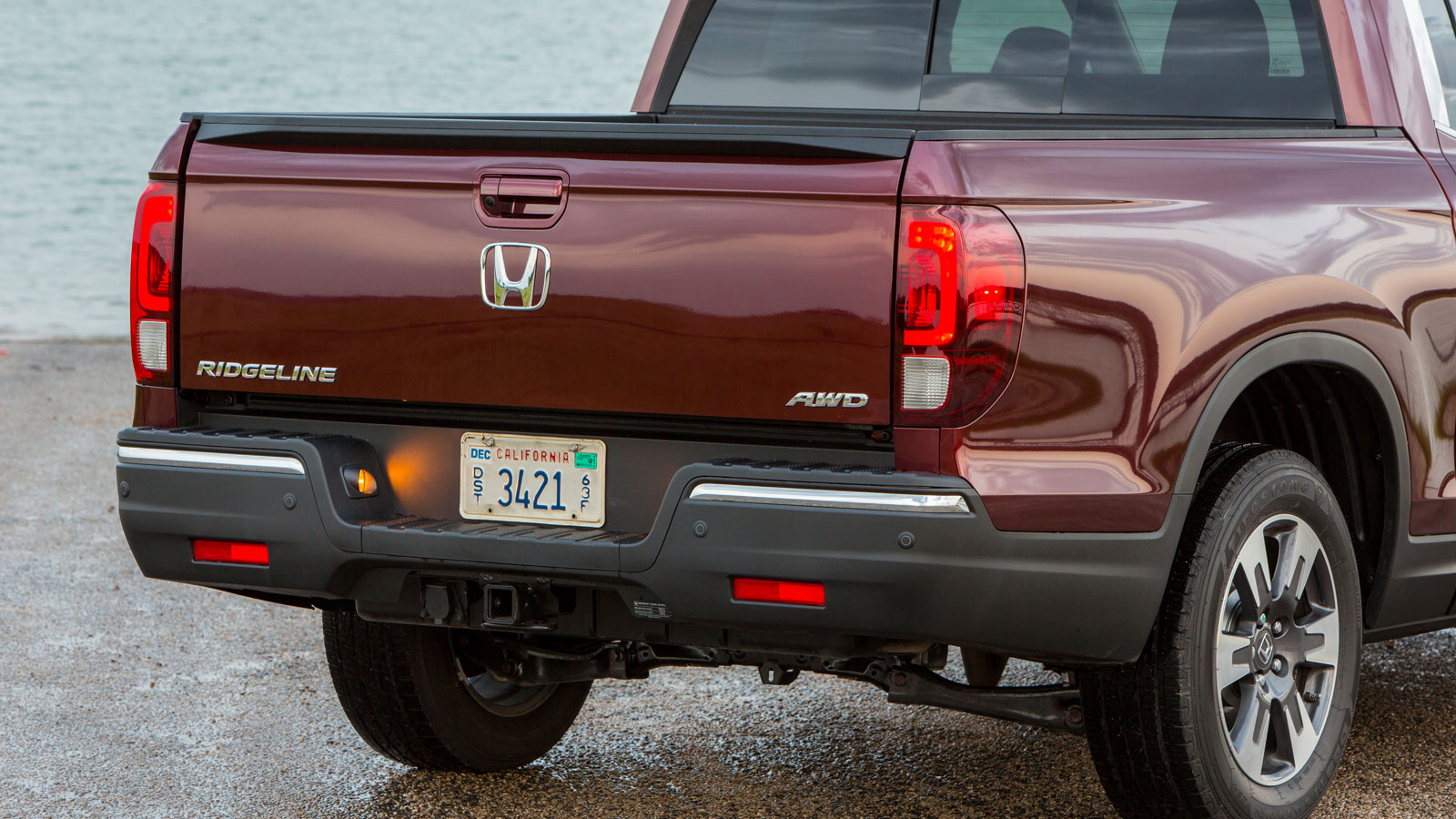 A photo of the tailgate on a burgundy Honda Ridgeline truck. 