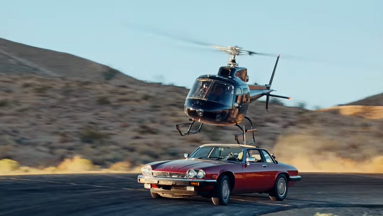 A screenshot from the music video of the XJSC driving on Willow Springs outrunning a black helicopter