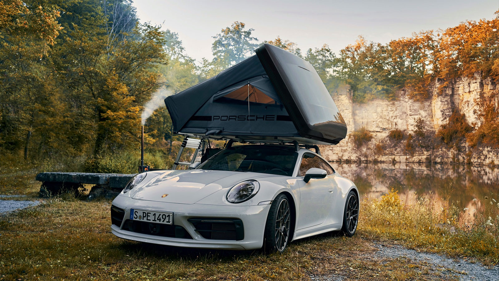 A photo of a roof top tent on the top of a Porsche 911. 