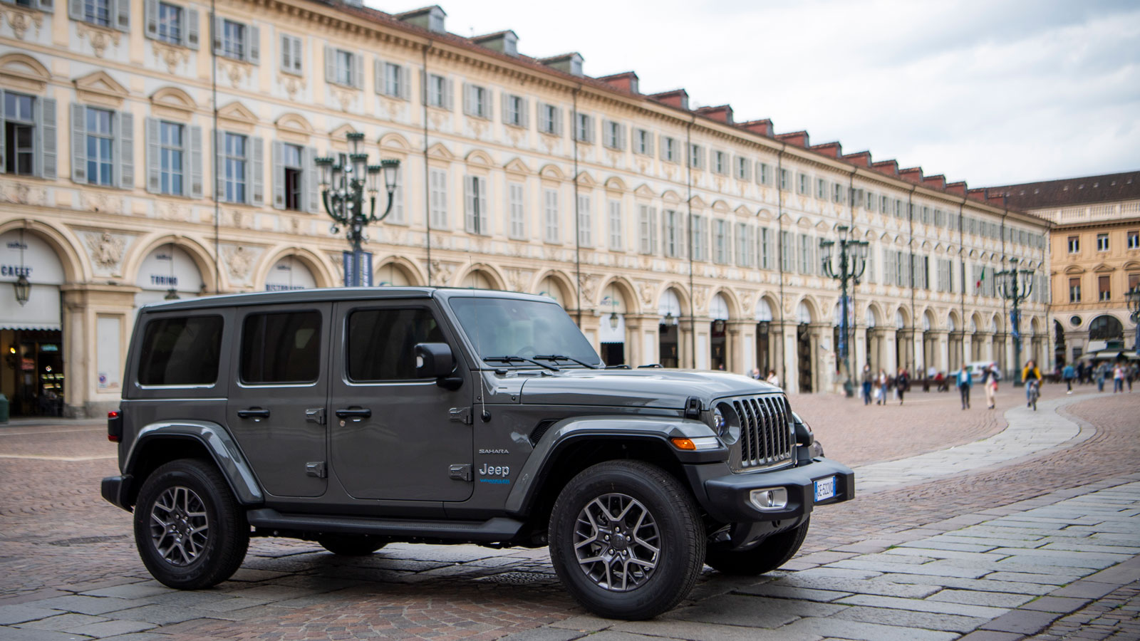 A grey Jeep Wrangler parked in a town square 