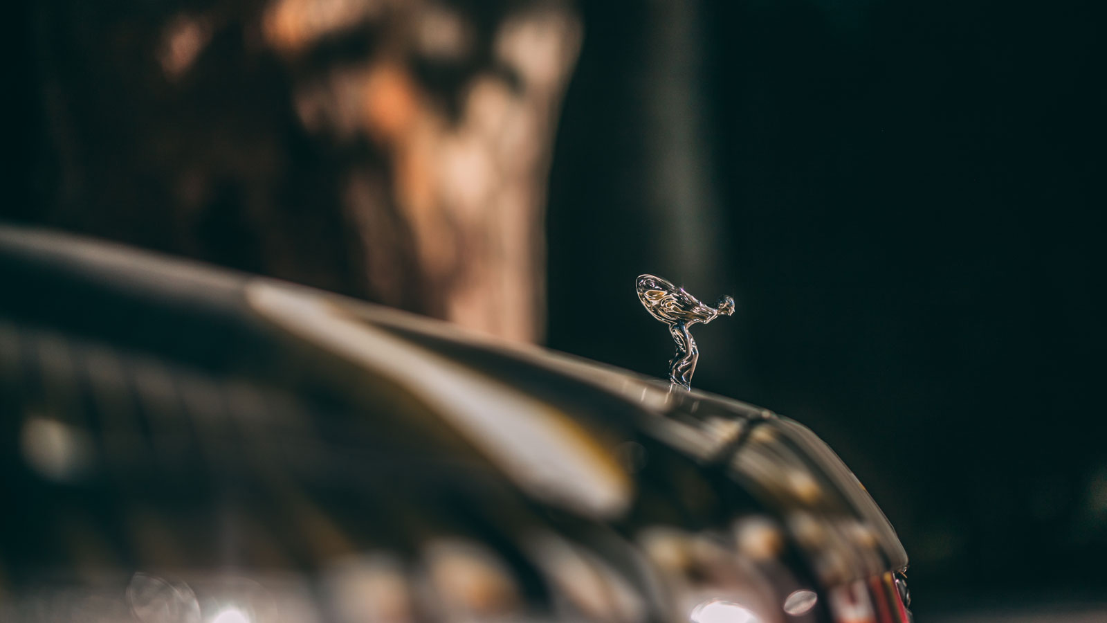 A close up photo of the Spirit of Ecstasy logo on the front of a Rolls Royce. 