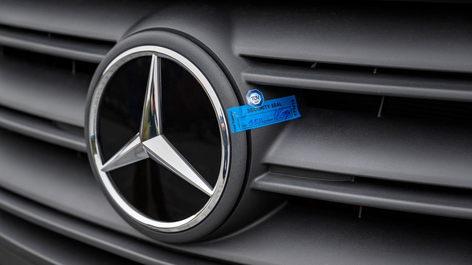 A photo of a security seal on the charging port of a Mercedes van. 