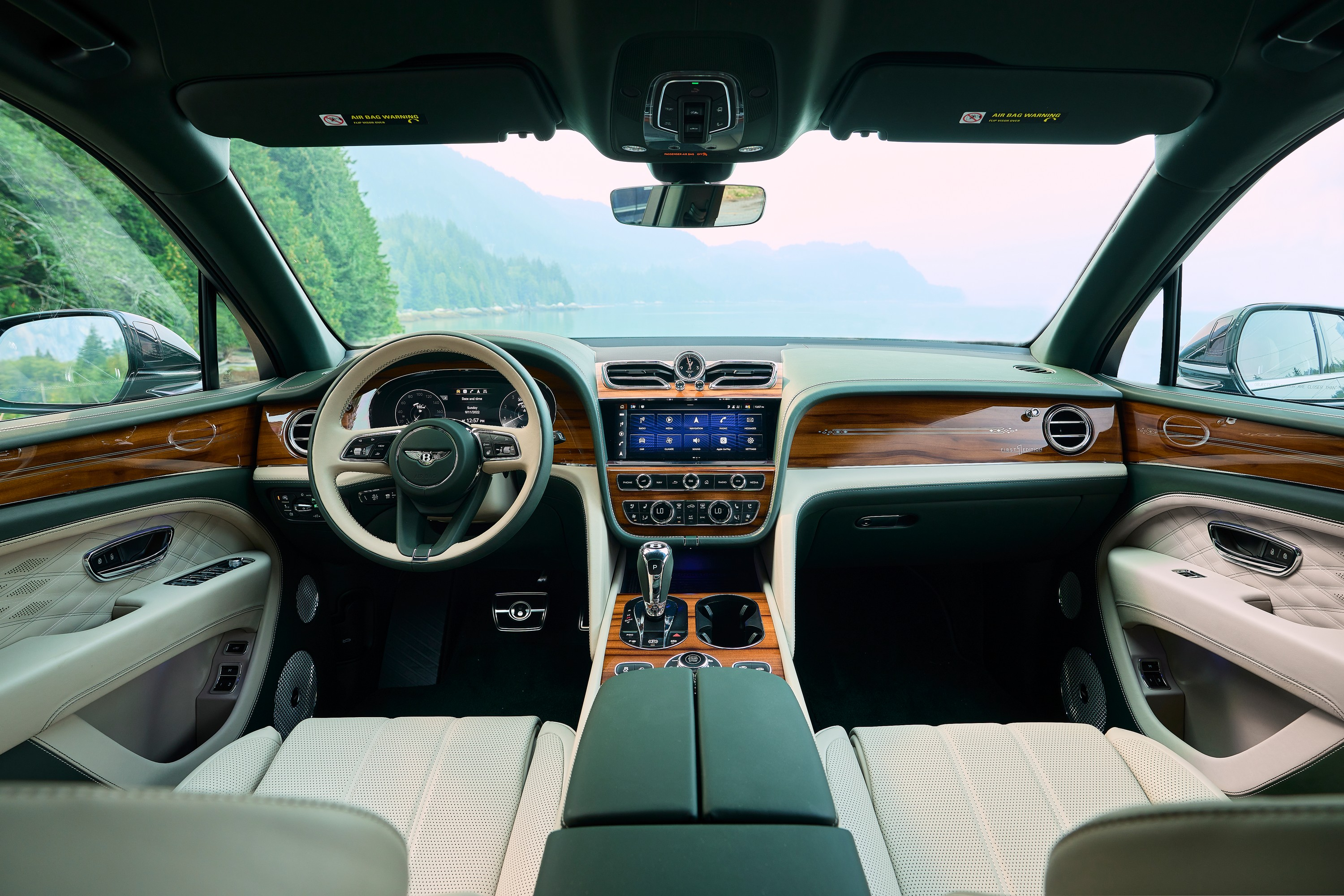 The interior of a Bentley Bentayga EWB, in green and tan leather and glossy wood.