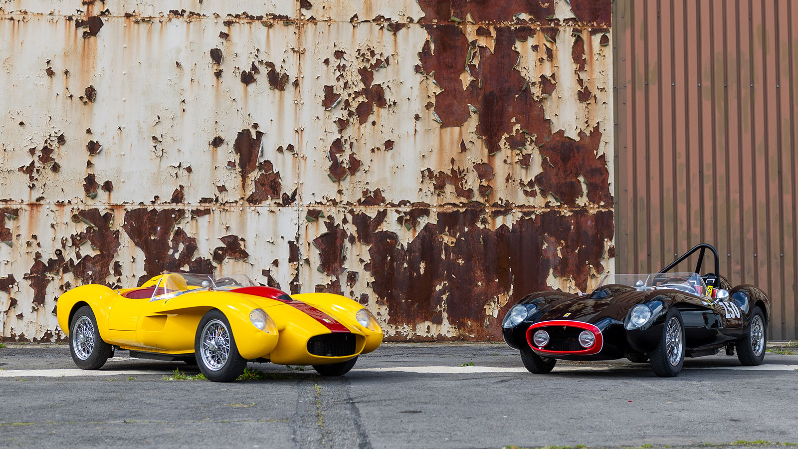 A photo of two Little Car Company Ferraris parked next to each other. 