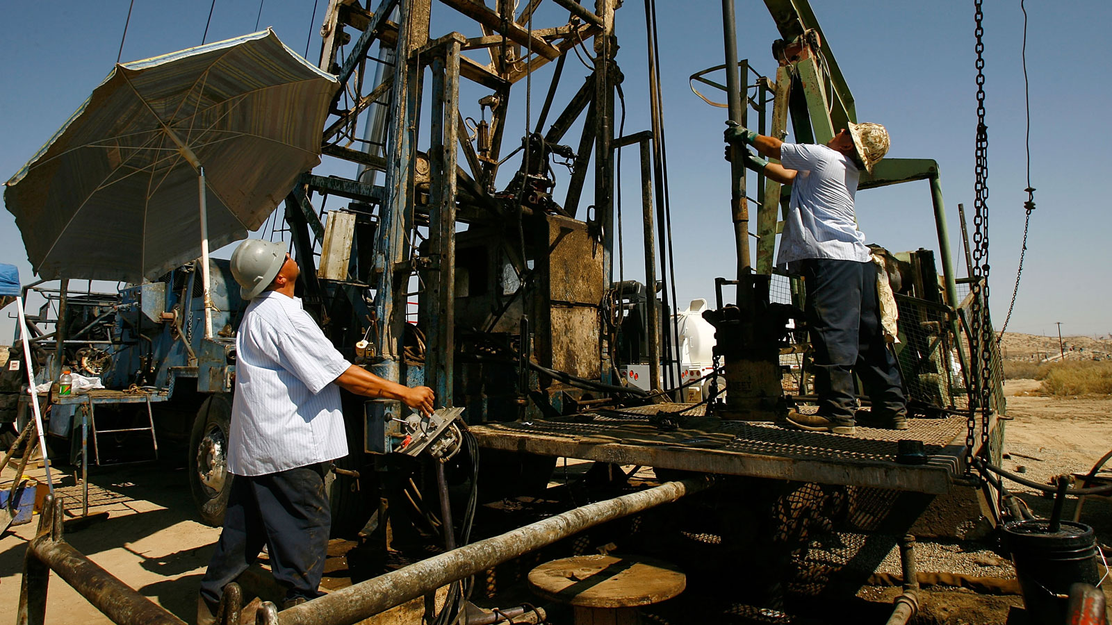 A photo of two people working on an oil drill in California. 