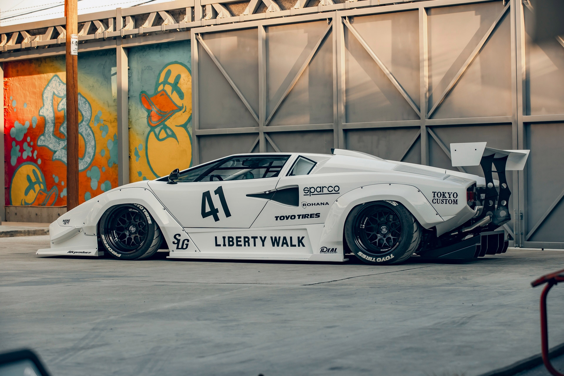 Side view of a white Lamborghini Countach with a Liberty Walk body kit